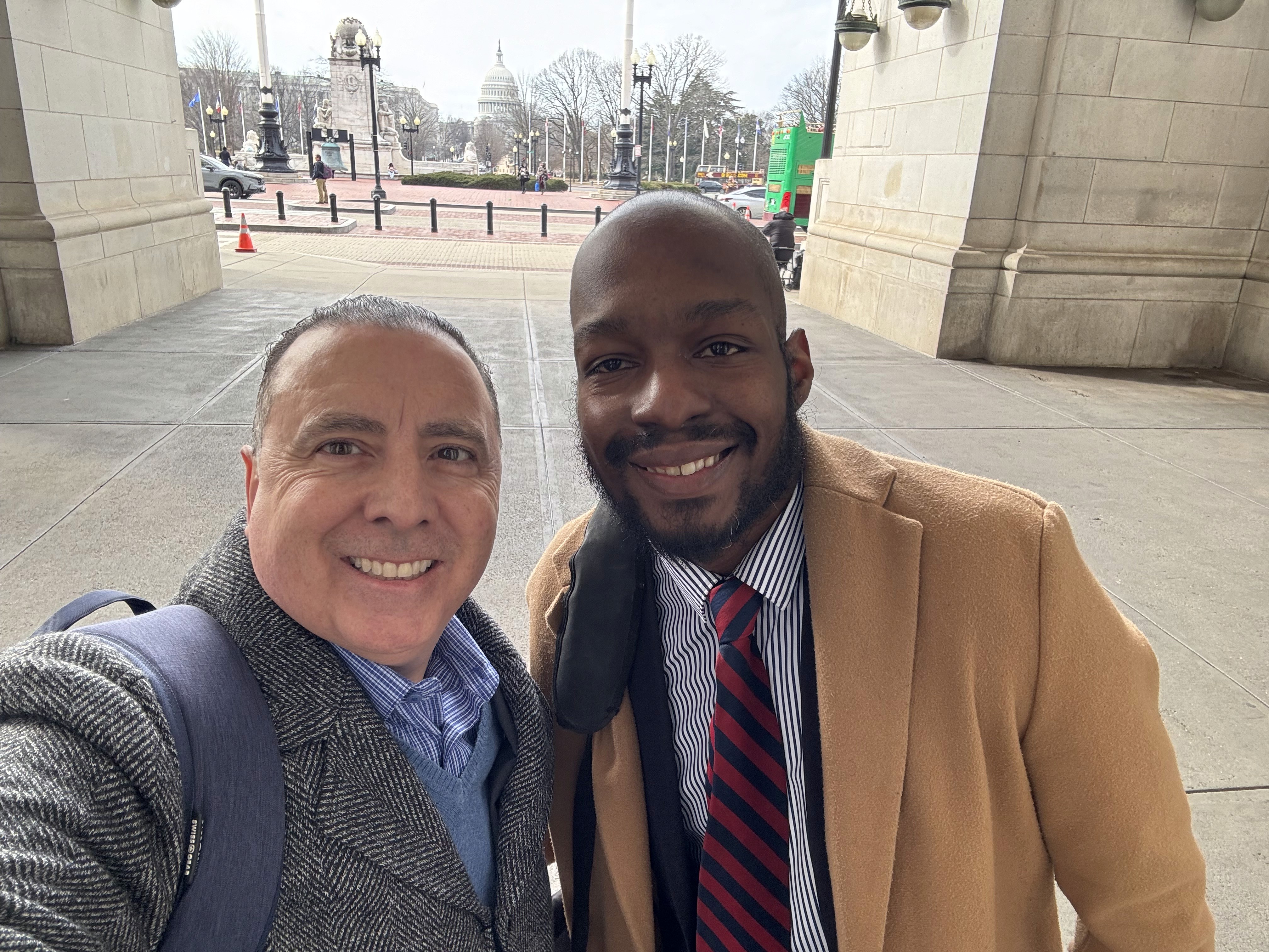 Two men take a picture in front of the Capital Building in Washington DC