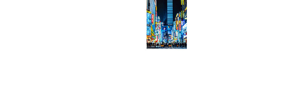 Illuminated street in Tokyo at night with bright neon signs