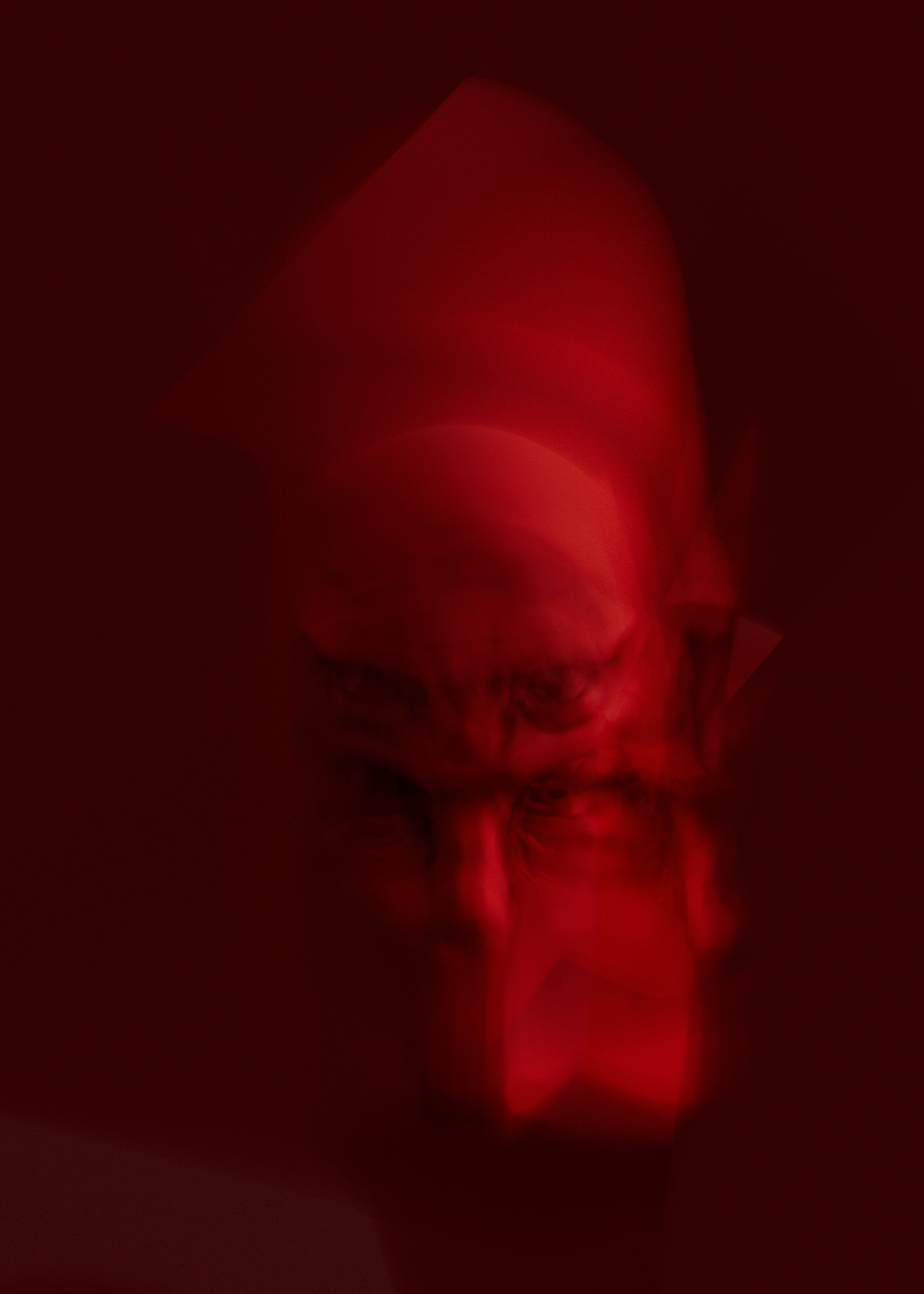 A red, blurred image of a face.