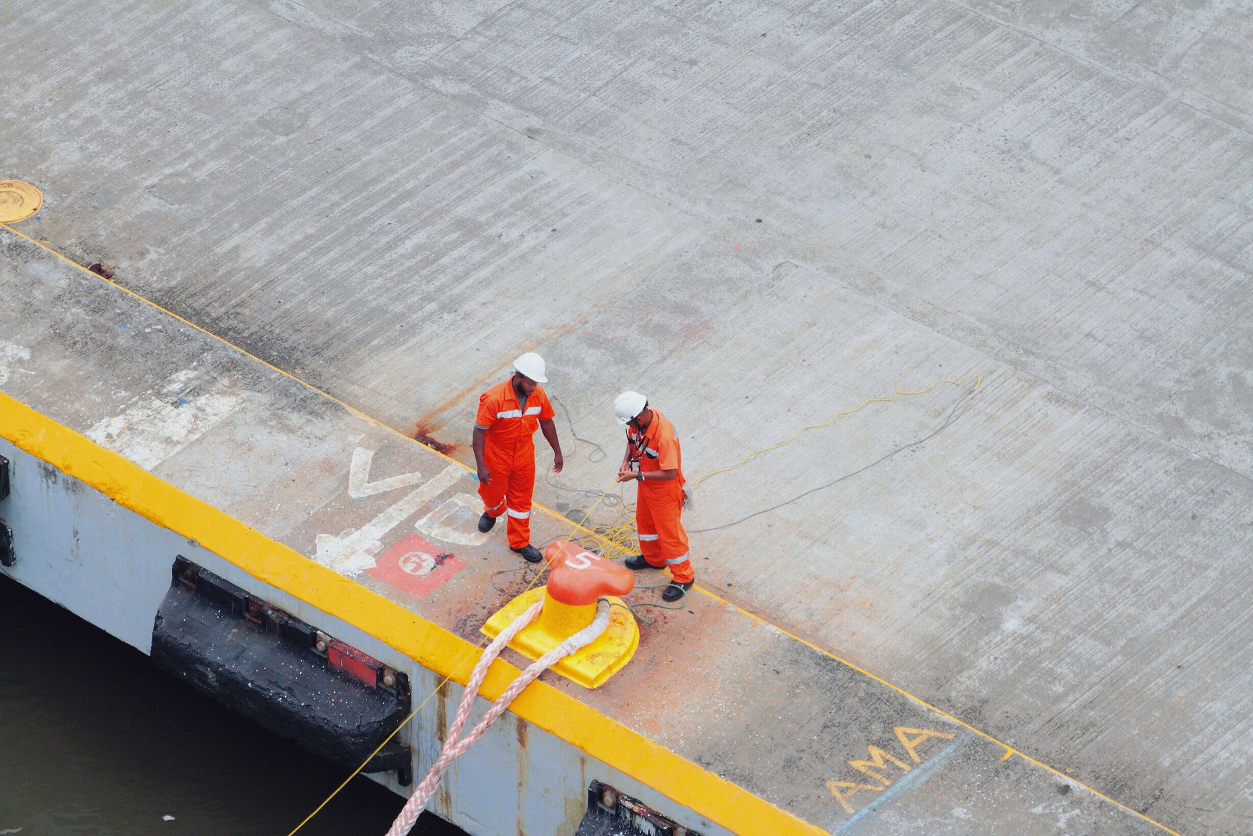 Port workers mooring line and working in challenging conditions that could lead to burnout