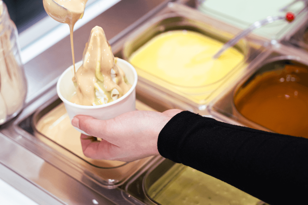 Mano che tiene yogurt mentre viene farcito