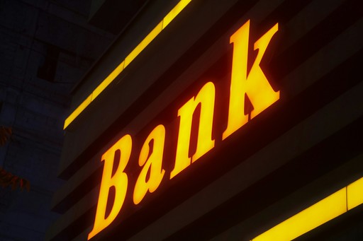 a bank sign lit up in the dark, illustrating RIB, IBAN, Prélèvement Automatique, and Cheques
