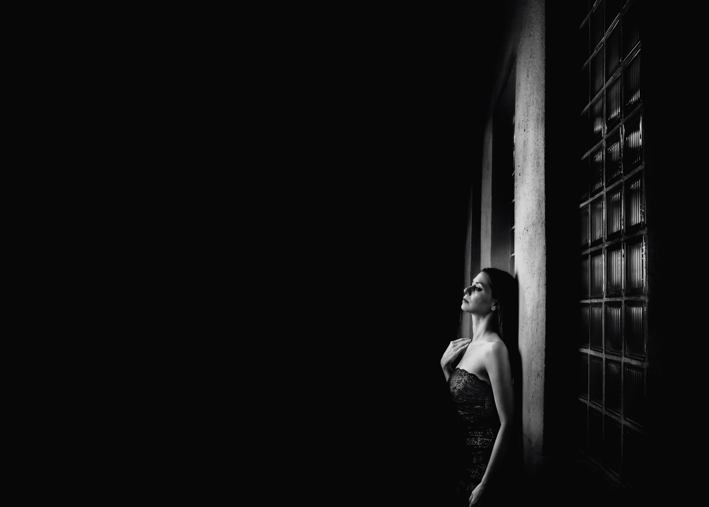 A person standing inside an icy blue cave near an opening