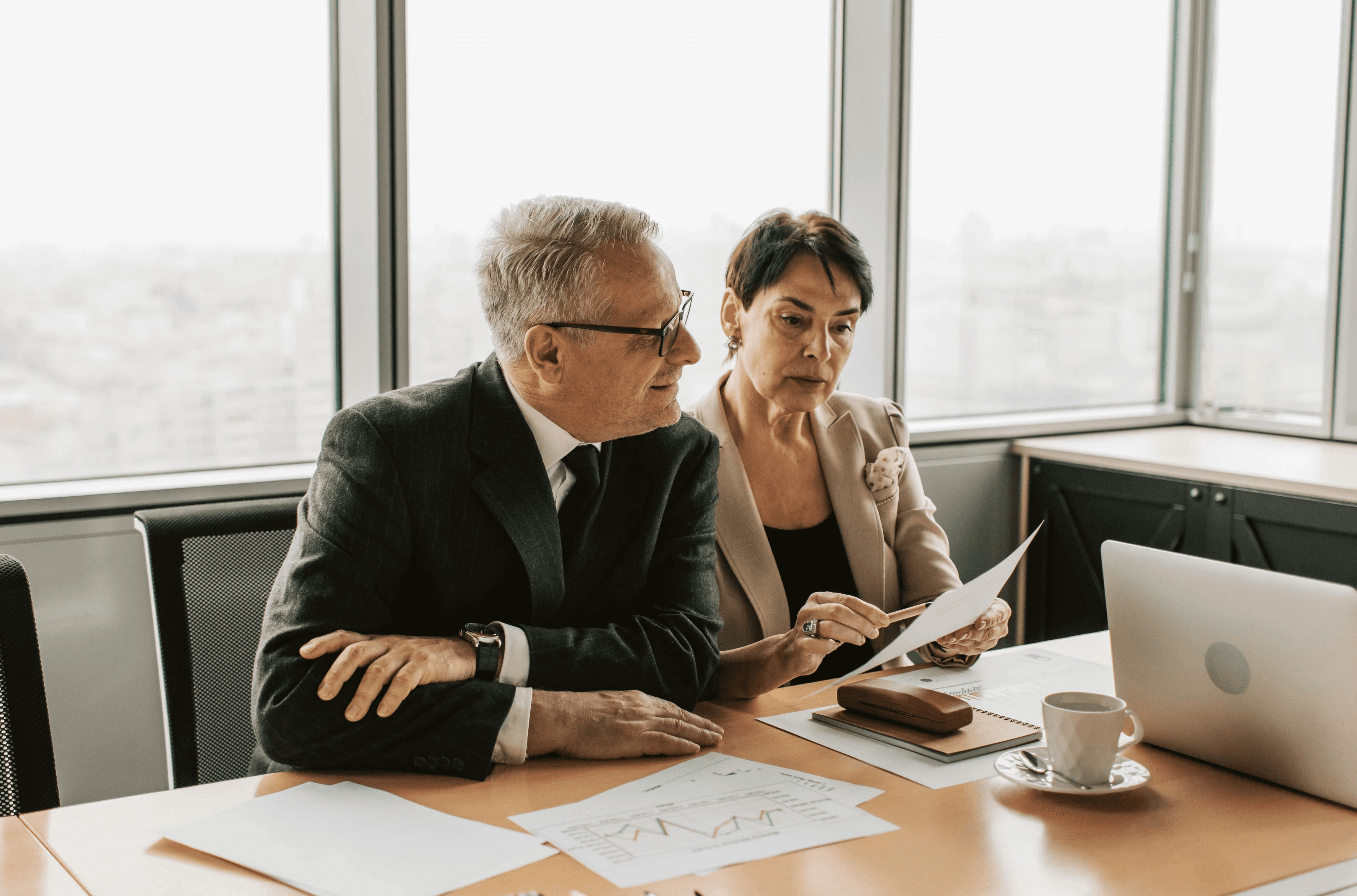 A strategic leader and senior leader at a financial firm review documents