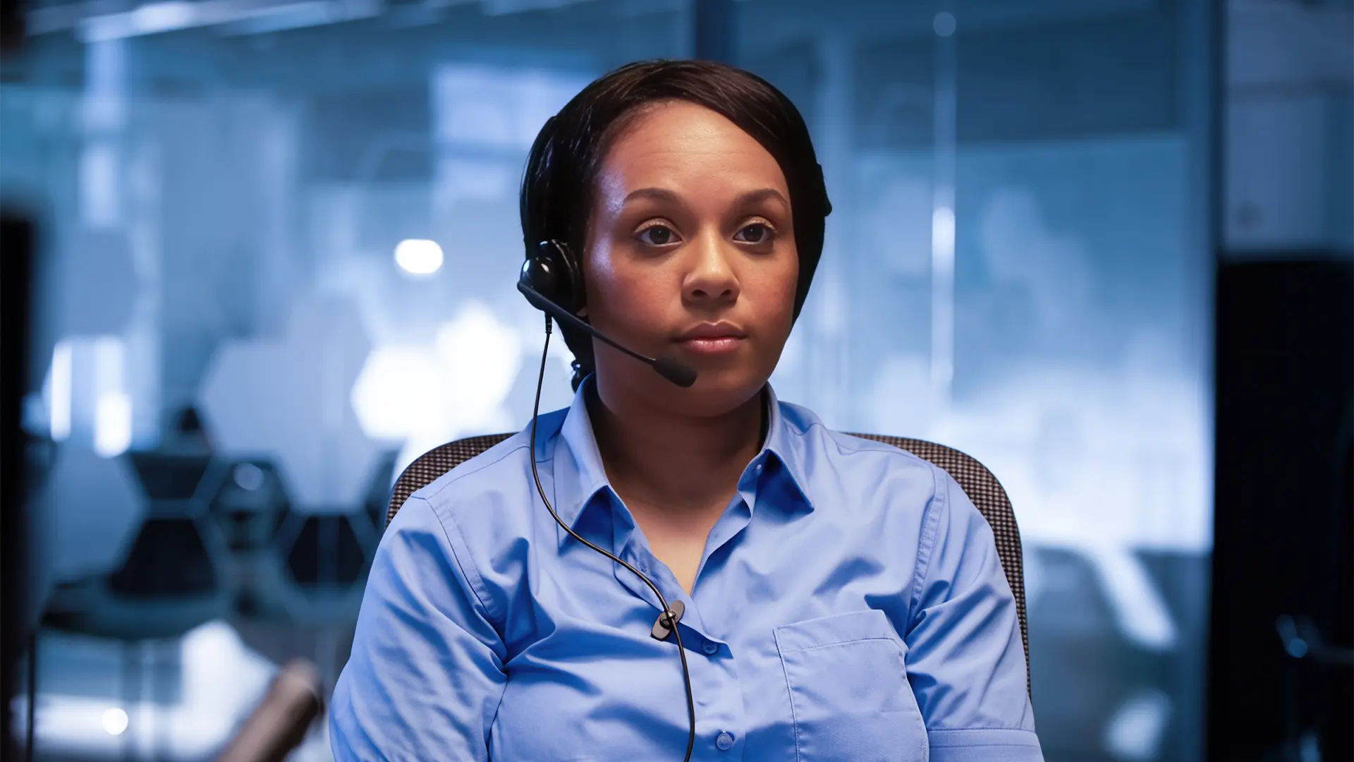 Emergency dispatcher wearing a headset in a control room environment