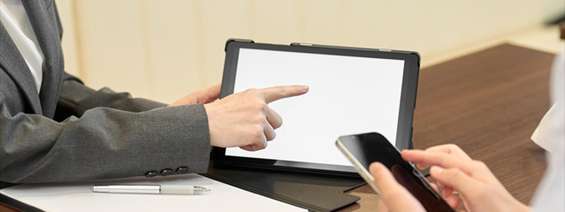 タブレットで説明するビジネスマンとスマホを持つ人