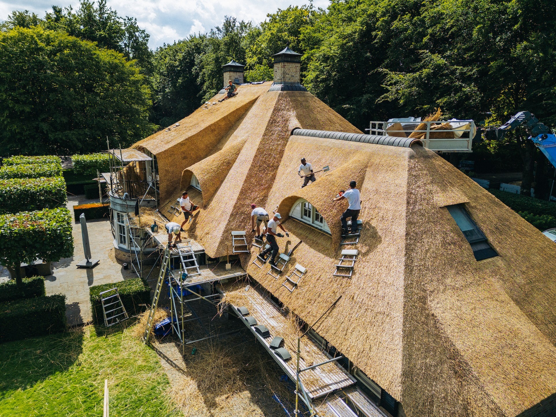 Het team van Rietdekkersbedrijf van Dijk aan het werk met de aanleg en afwerking van rieten dak