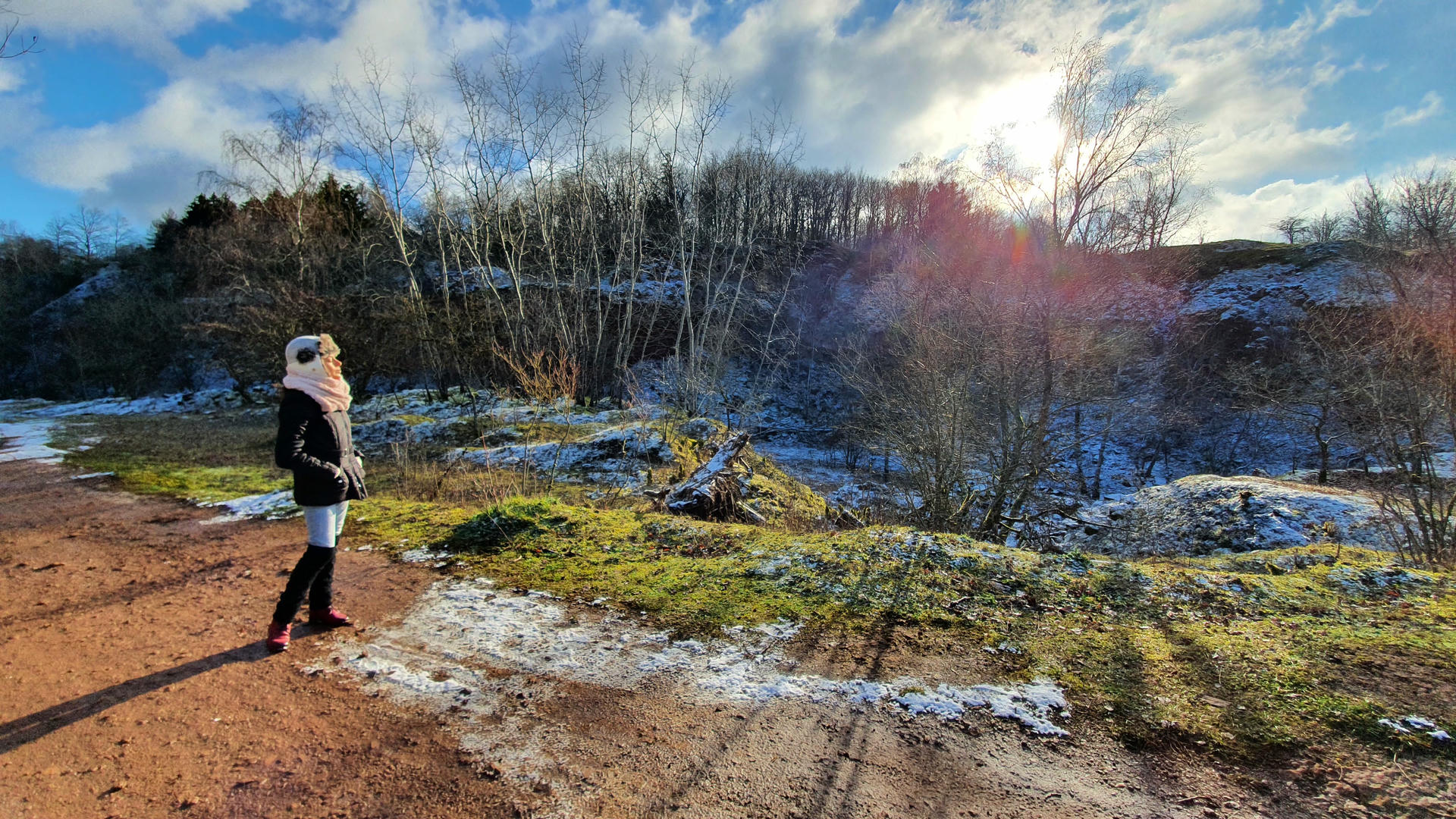 Samira standing at edge of cliff looking at clouds