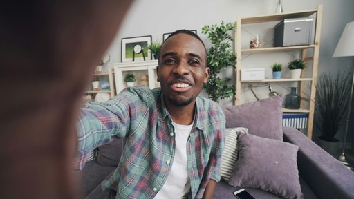 a man sitting on a couch with a cell phone in his hand
