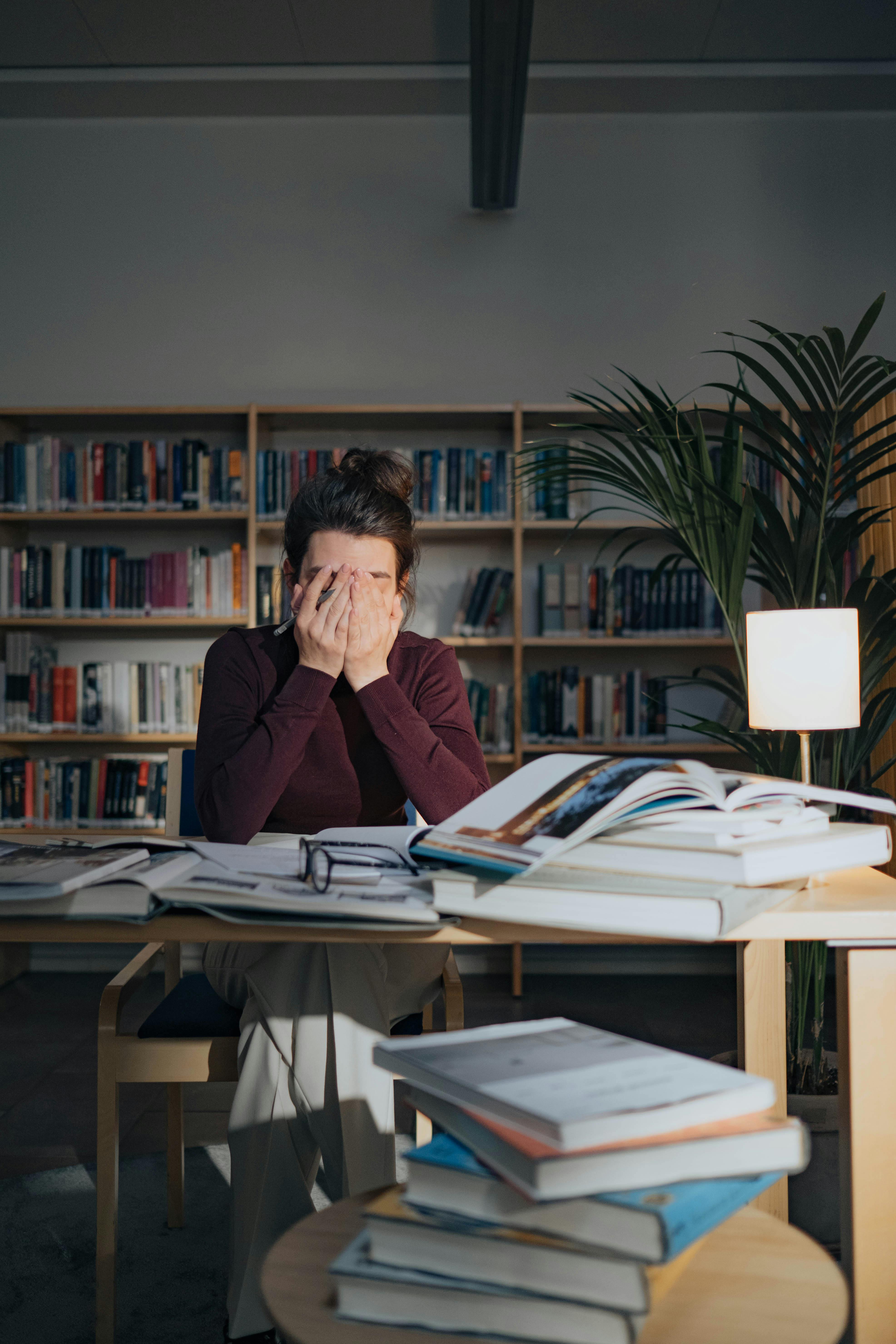 Studnt stressed in front of a stack of papers