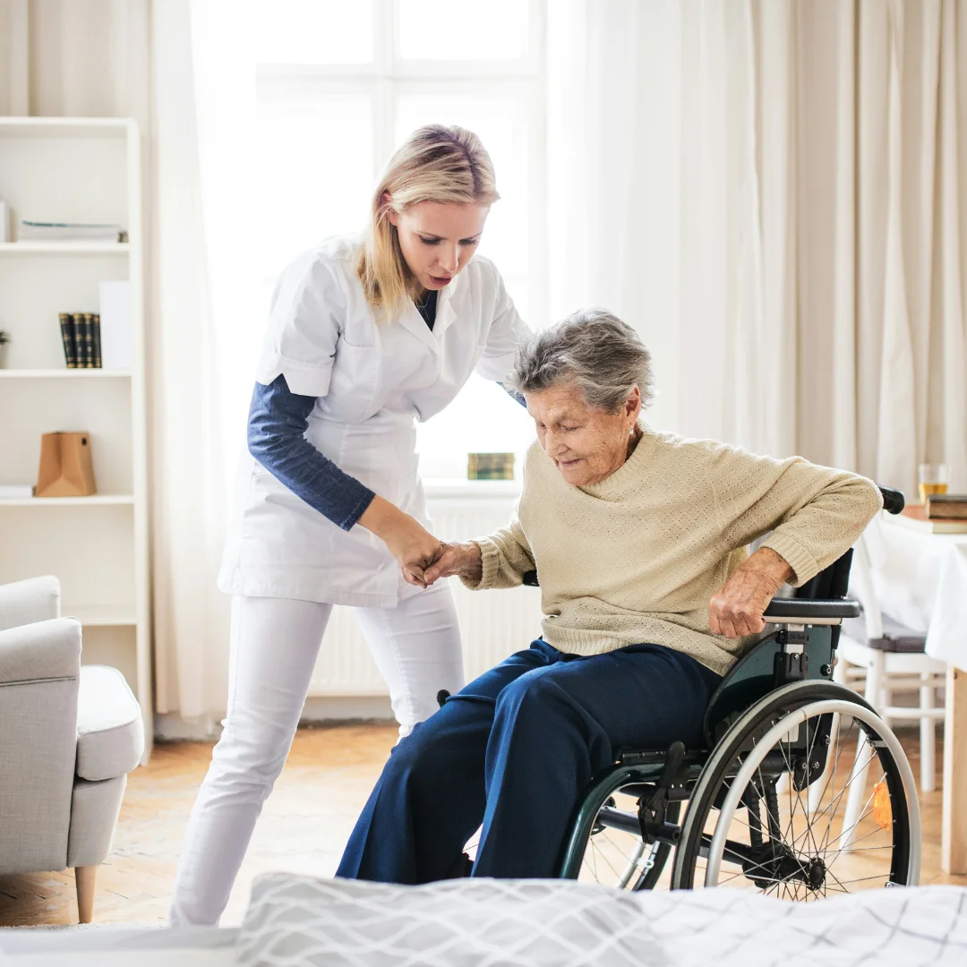 Community nurse supporting older woman in wheelchair with wellness activities at home