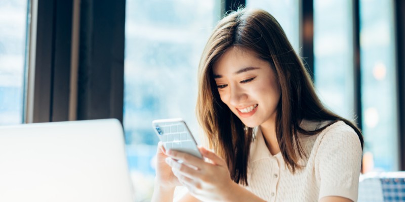 A girl happily using her phone