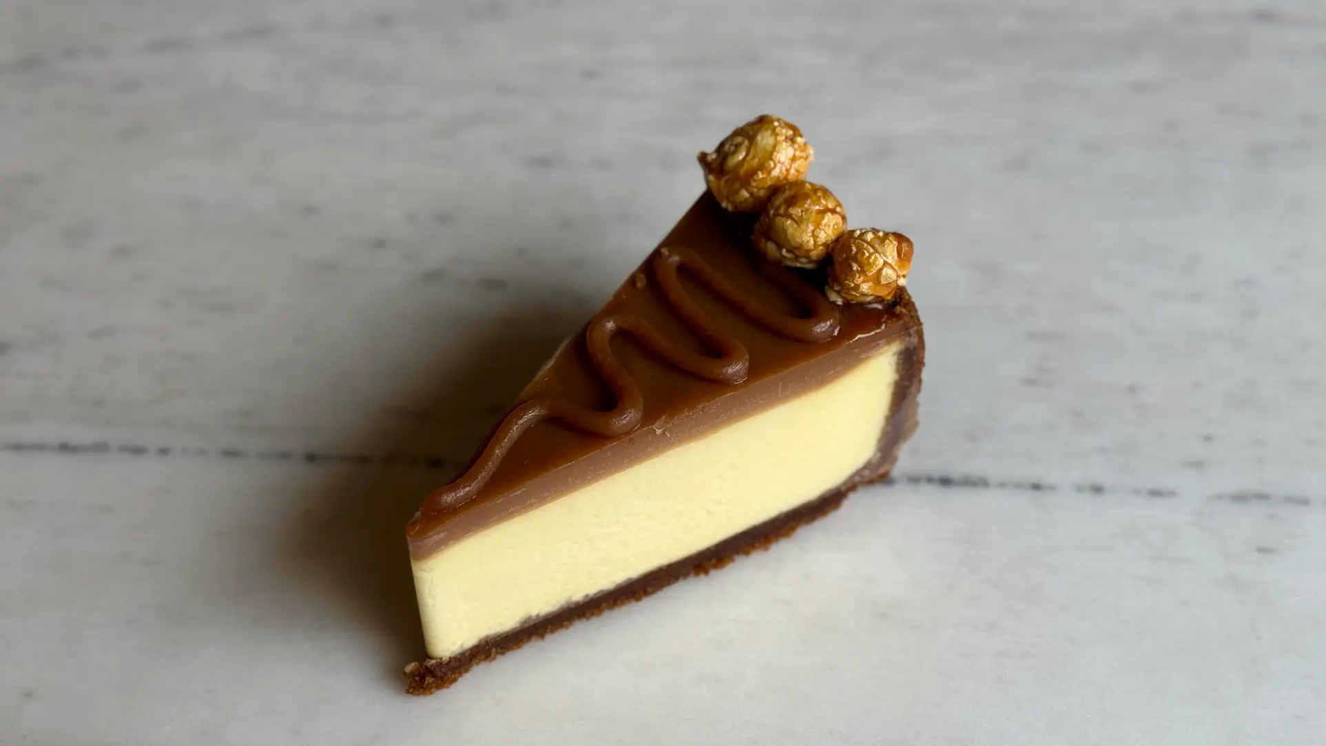 Layered cheesecake slice with chocolate glaze and hazelnut truffles