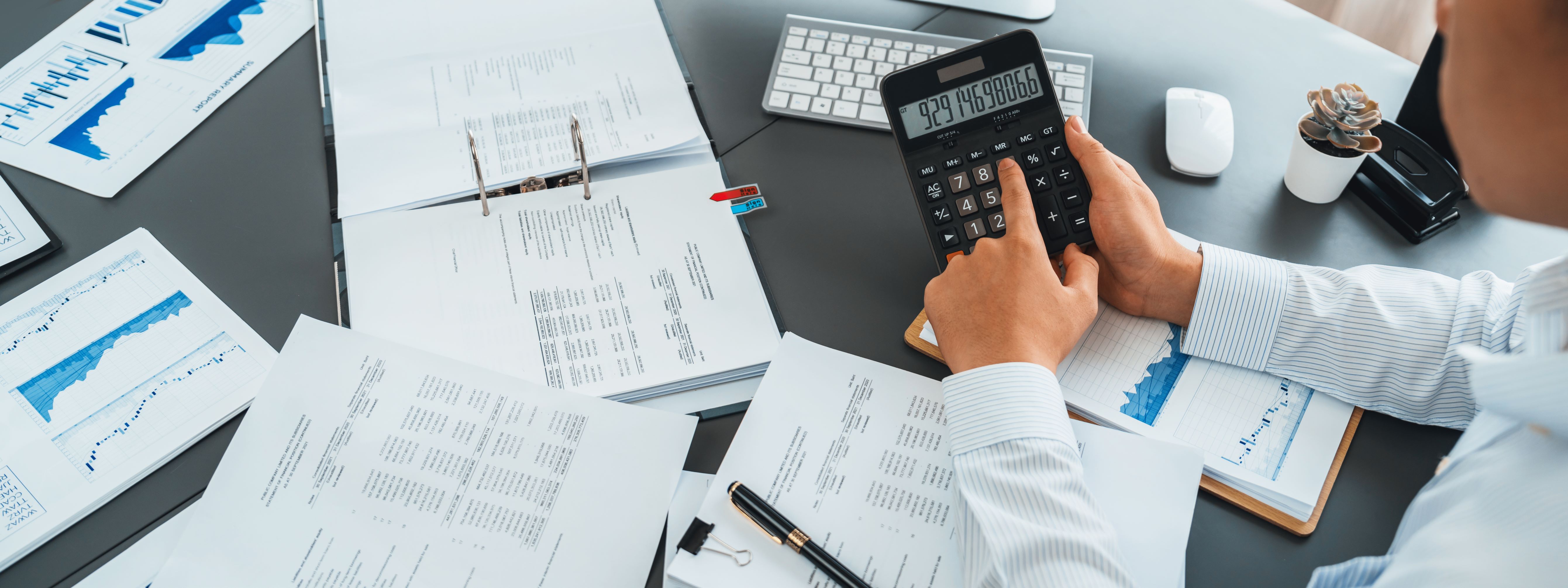 a group of people sitting around a table with laptops