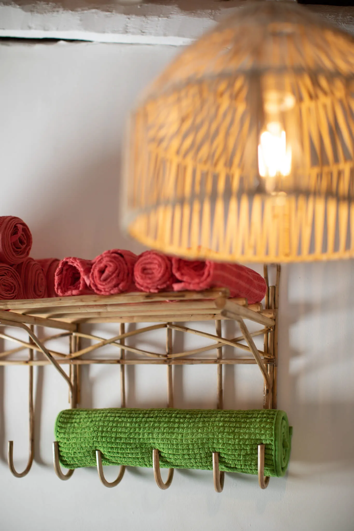 Cane pendant light and rolled towels — handcrafted details at Casa Jaali