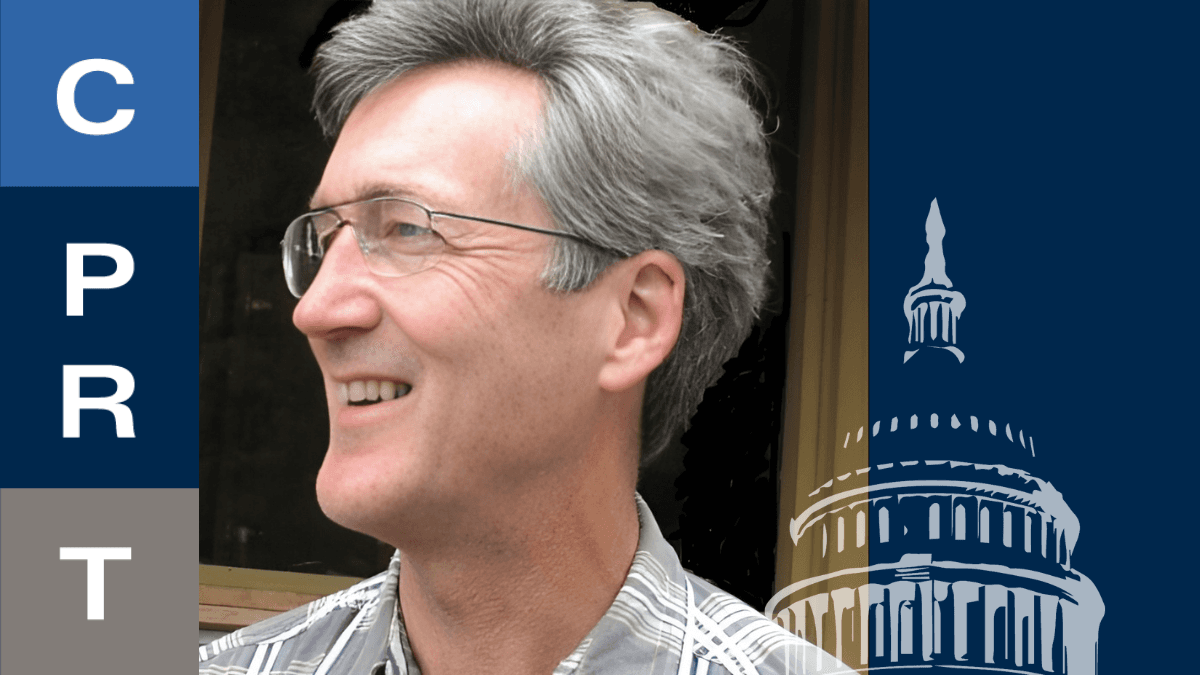 A man with gray hair and glasses smiles, with text on the left side that reads "C P R T".