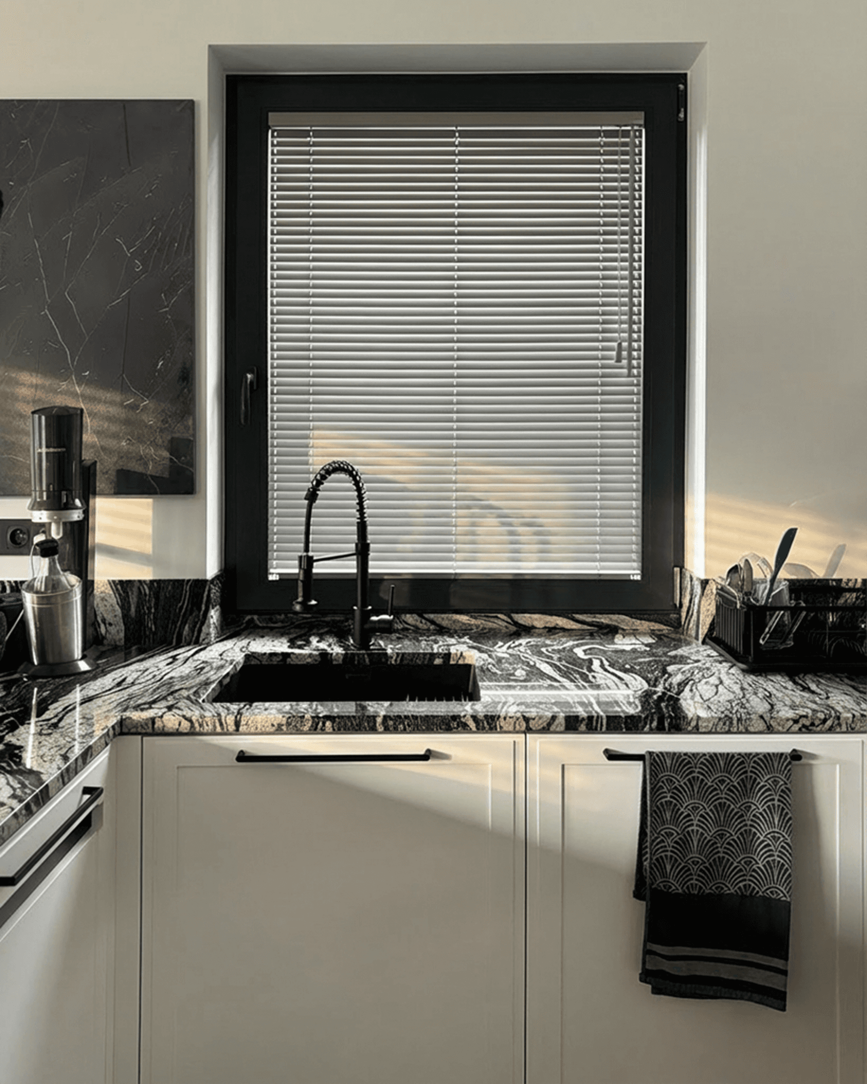 Nowoczesne szare żaluzje aluminiowe zamontowane w czarnej ramie okiennej nad kamiennym blatem. Profesjonalny montaż osłon okiennych HeyShade Pruszków.