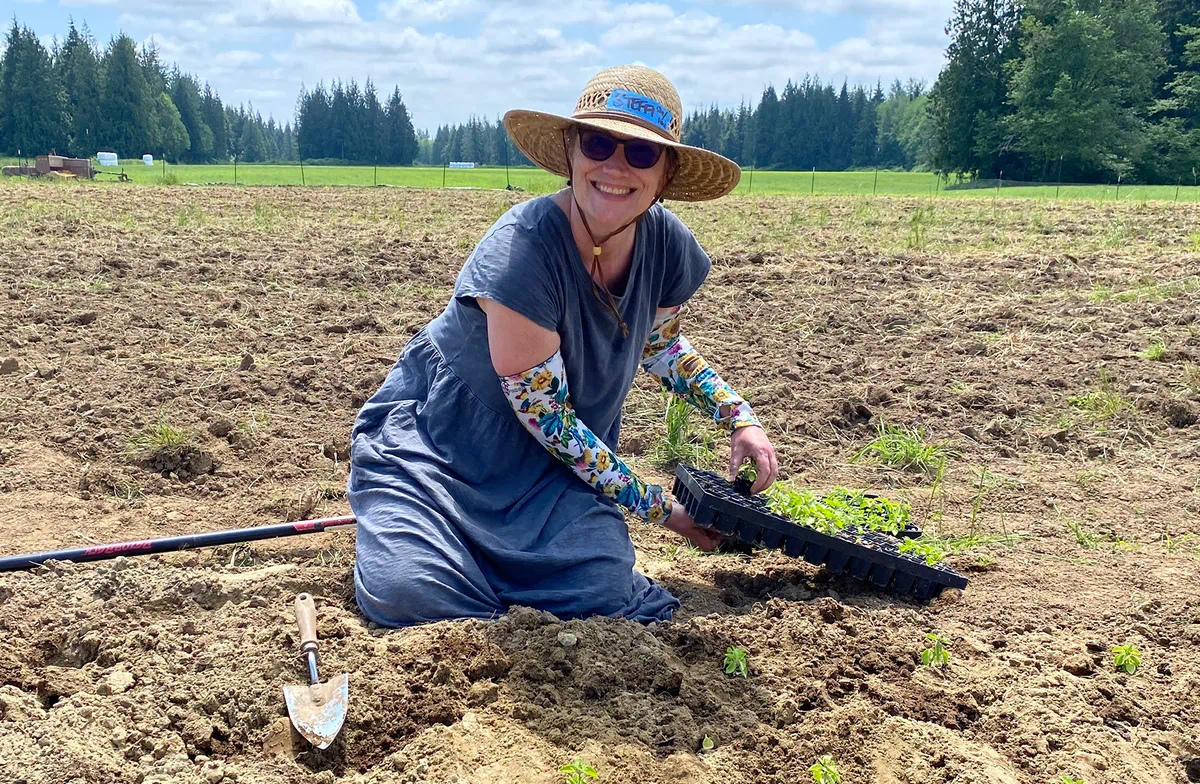 A woman planting and tending a small garden plot on the land.