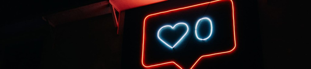 Neon heart and zero in red and blue signifying social media interactions.