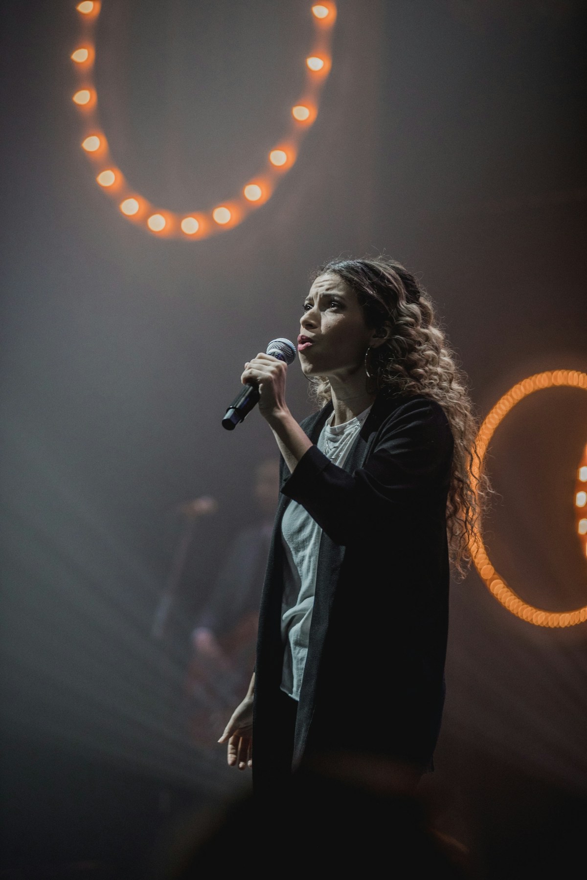 Nell singing with ring lights behind her