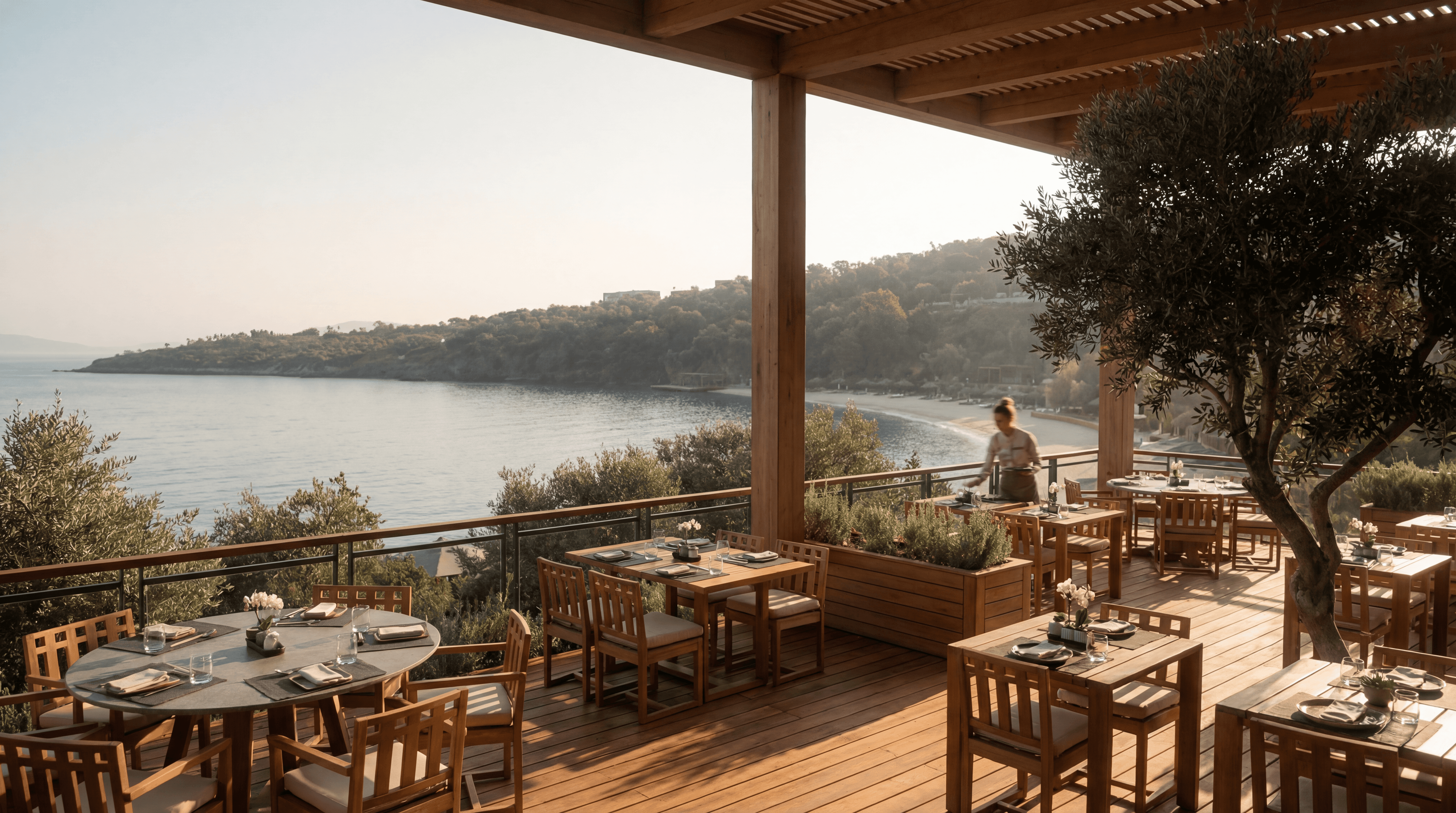 Open-air waterfront restaurant terrace at Mandarin Oriental Bodrum with wooden pergola and sea view