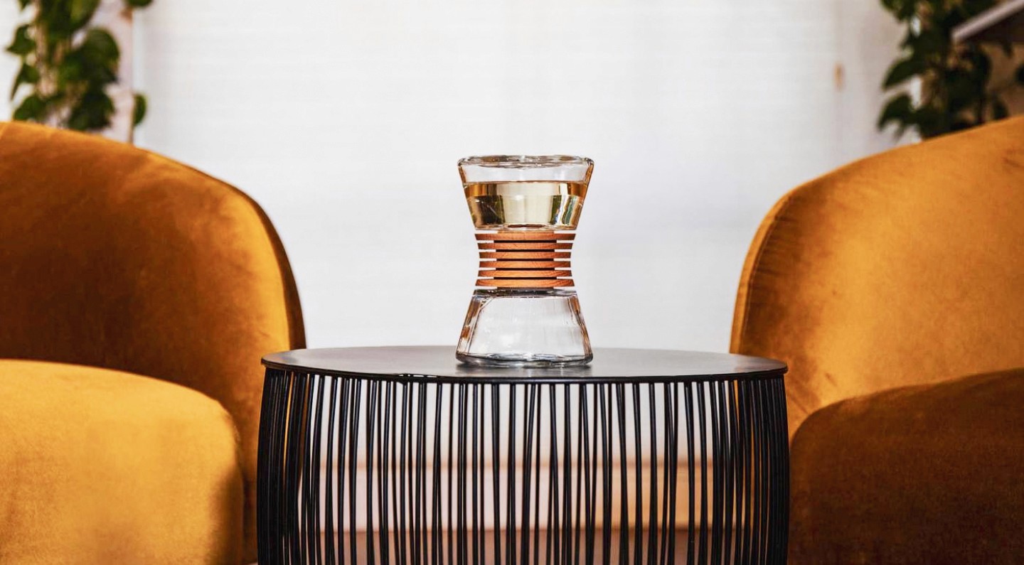 Fragence bottle on table between two chairs.