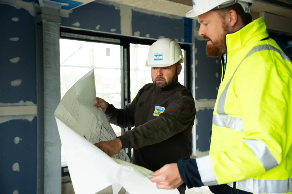 Zwei Brömer-Kollegen auf der Baustelle mit einem Plan in der Hand