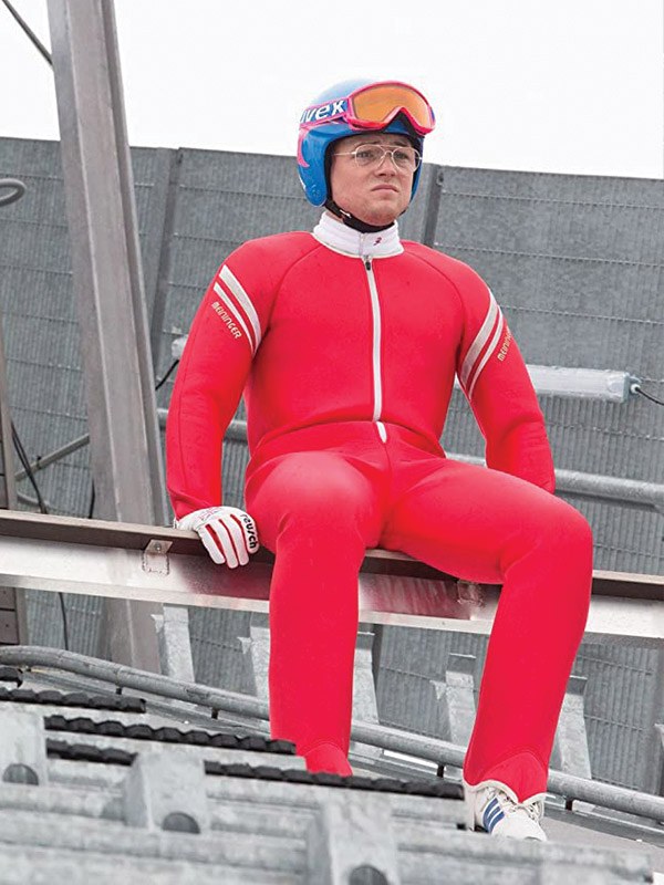 Taron Egerton as Eddie the Eagle in the red jumping suit on the hill