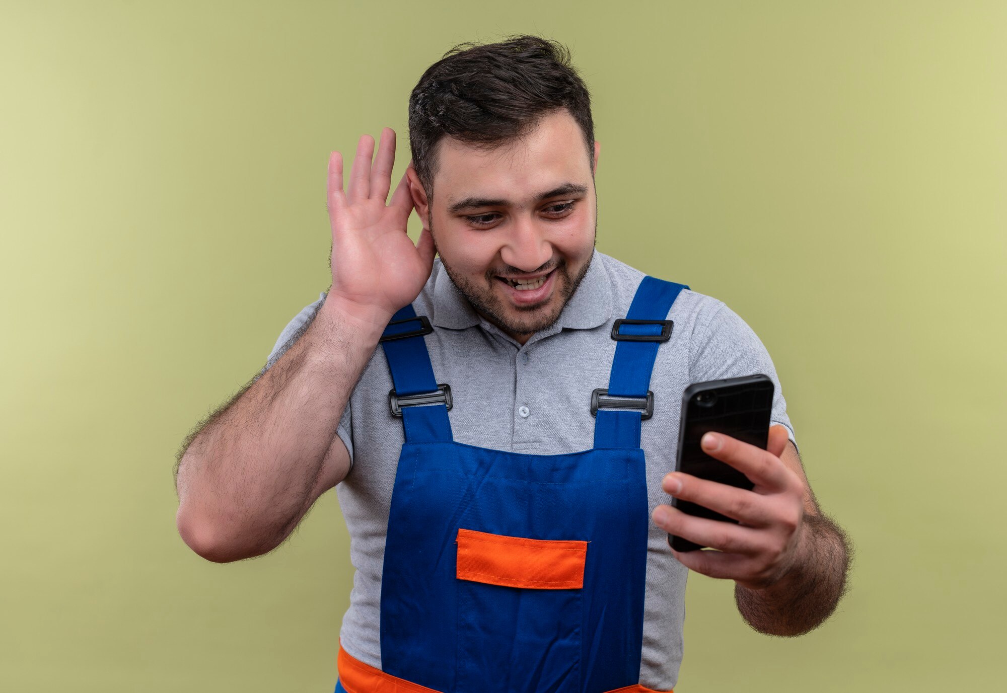 Installateur in werkkleding belt klant met smartphone tijdens werkdag