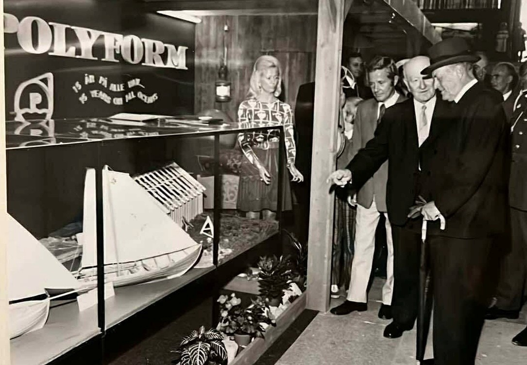 A person wearing a virtual reality headset stands in front of multiple screens, engaged in a digital experience.