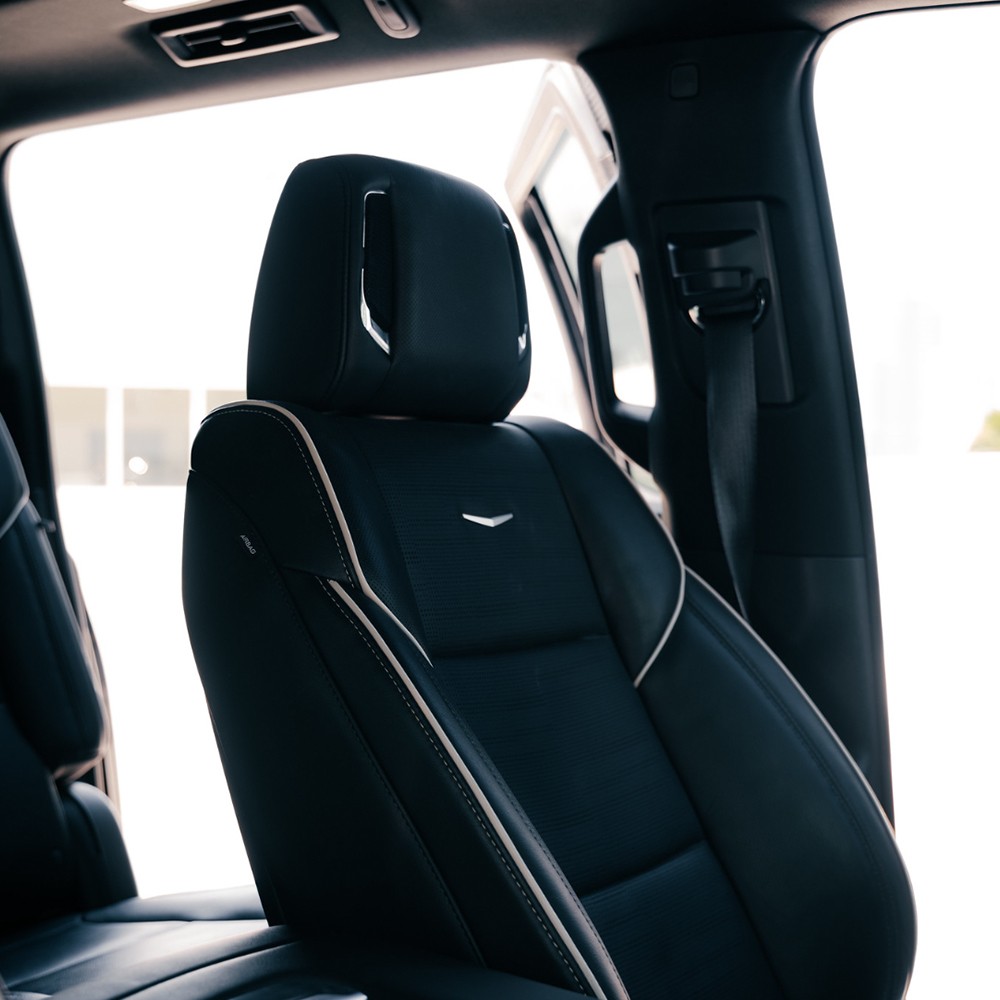 Front seat headrest of Cadillac Escalade with embroidered logo and leather stitching
