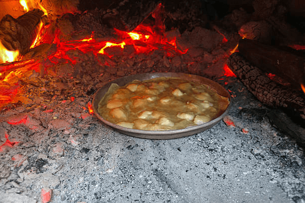 Traditional Maori hangi cooking method with food prepared underground