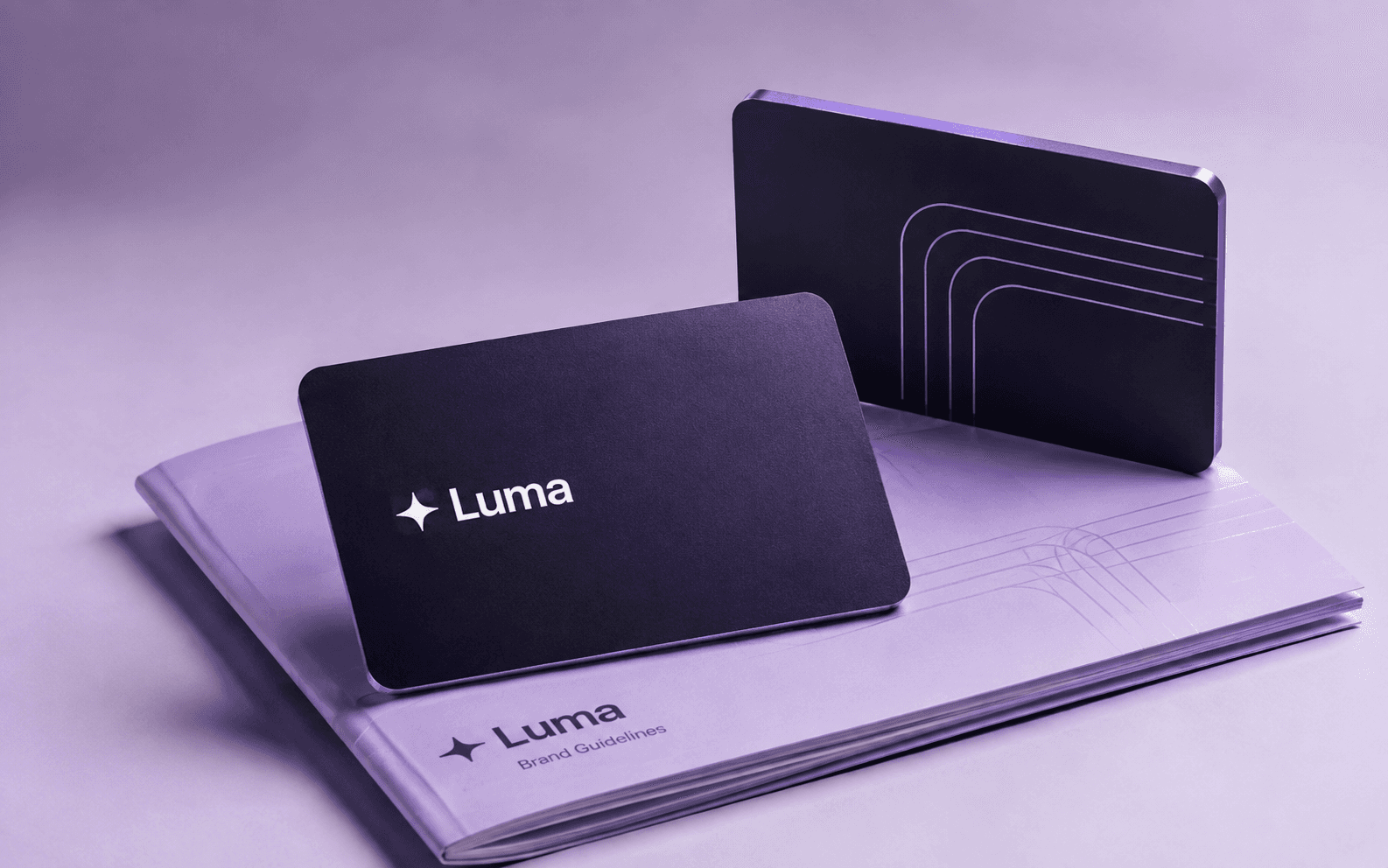 LUMA financial brand concept: violet card prototypes on a lavender brand guideline booklet.