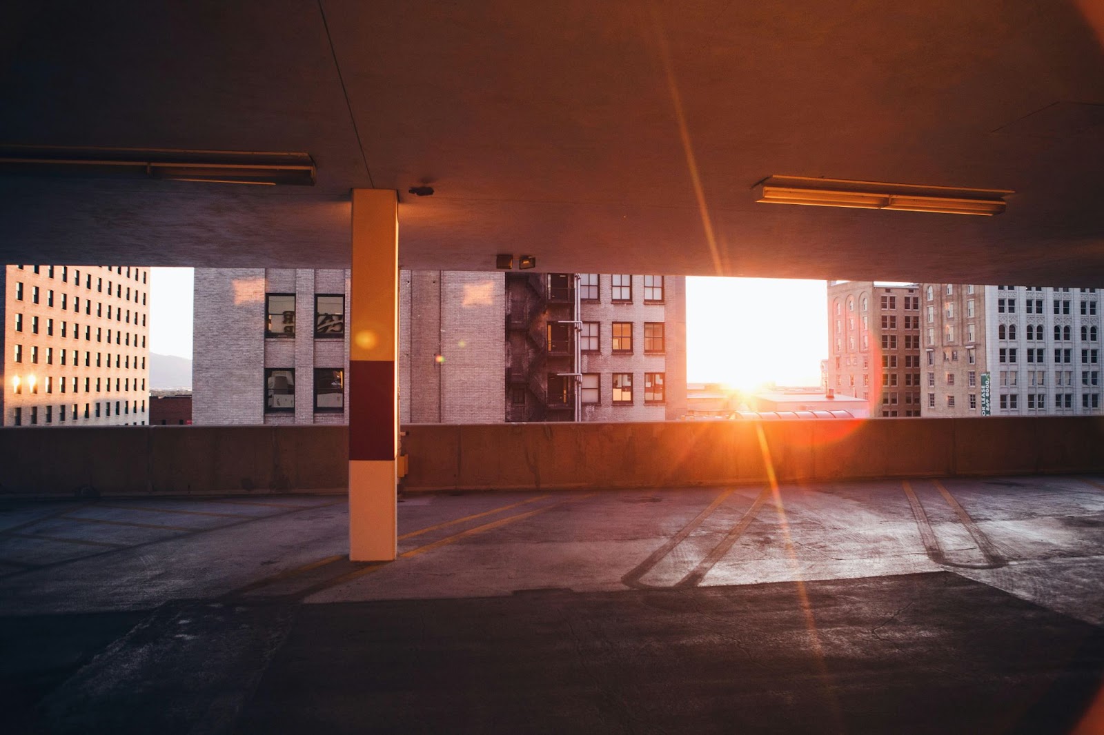 An empty upstairs garage parking spot with sunlight coming through