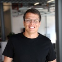 Profile portrait of a man in a white shirt against a light background