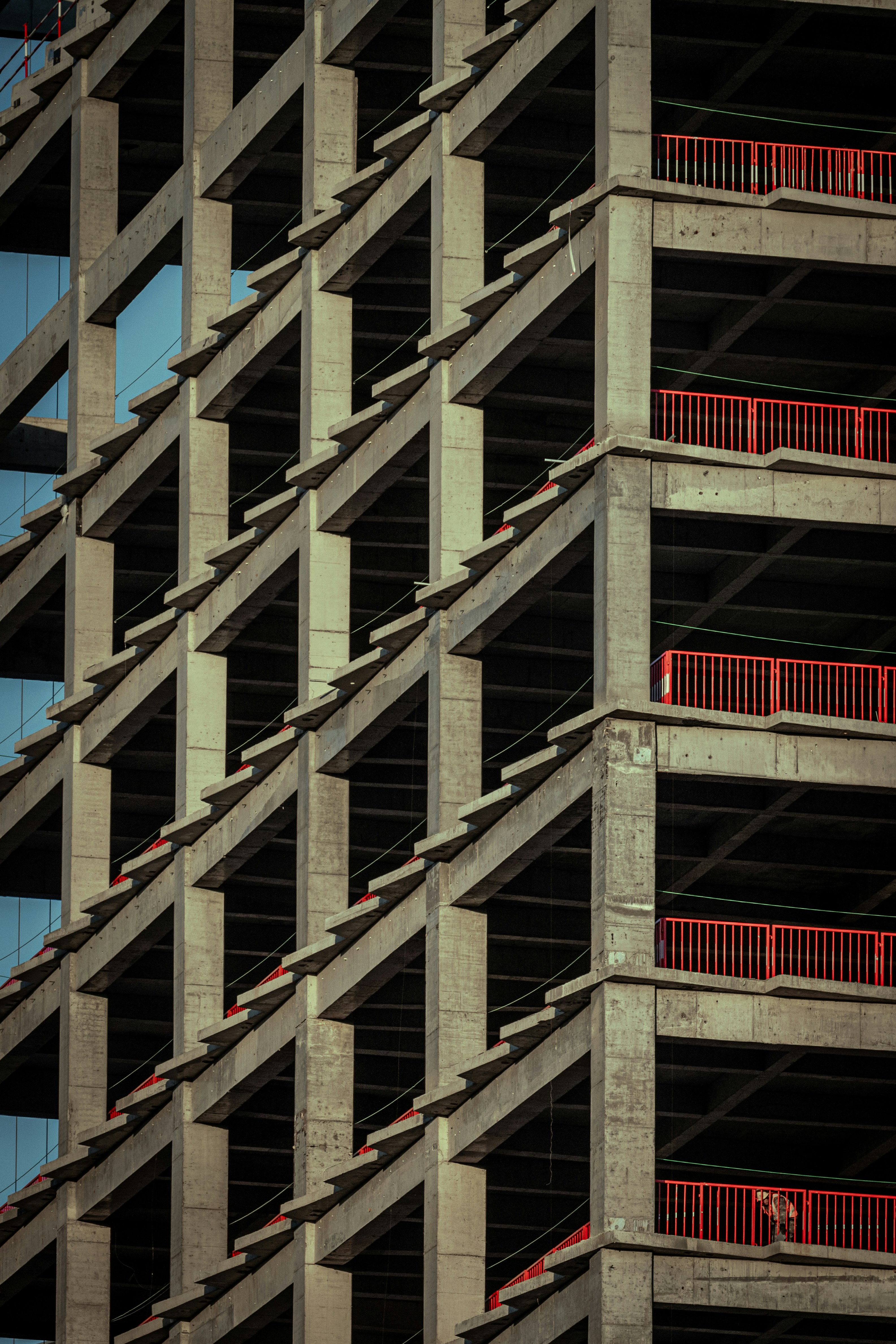 Concrete building under construction with red railings.