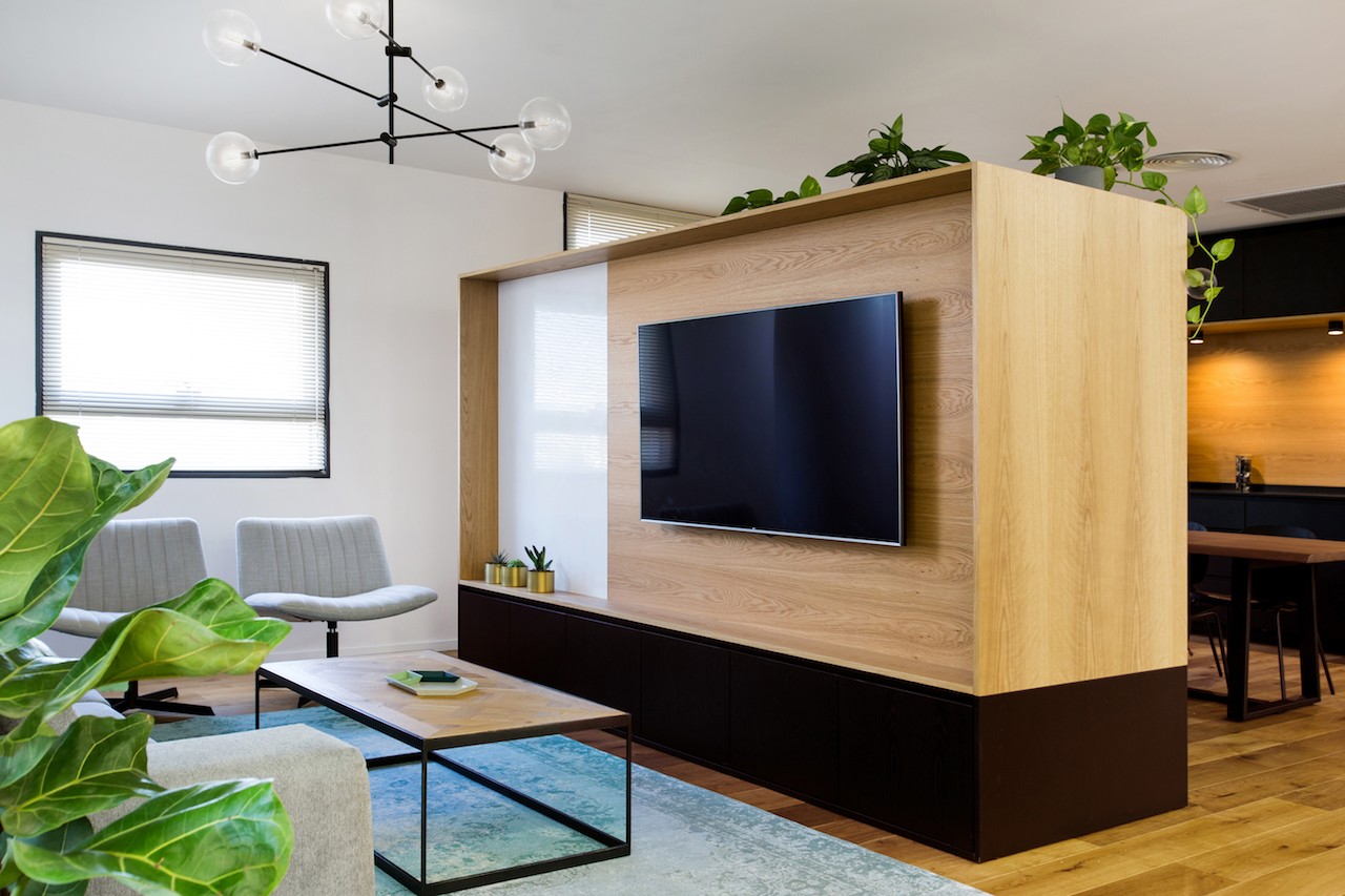 אזור אוכל משרדי עם ישיבה משותפת ותכנון פתוח המשלב אור טבעי ונוף חוץ