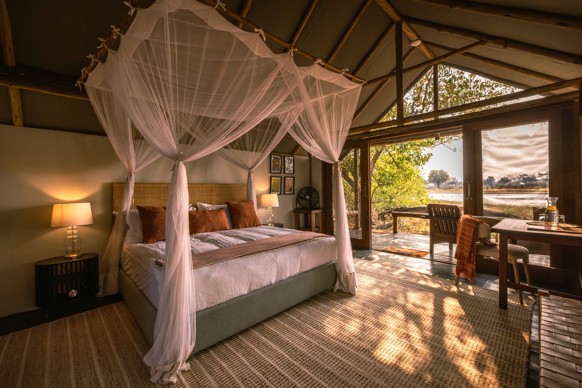Kujwana Delta Ride, Okavango Delta, Botswana. Lyxigt och rymligt boende på Kujwana Camp. Vackert bäddad dubbelsäng med myggnät runtomsig, mjuk matta på golvet, lampor som ger ett mysigt sken och öppna dörrar från rummet som har utsikt över Okavango Delta.