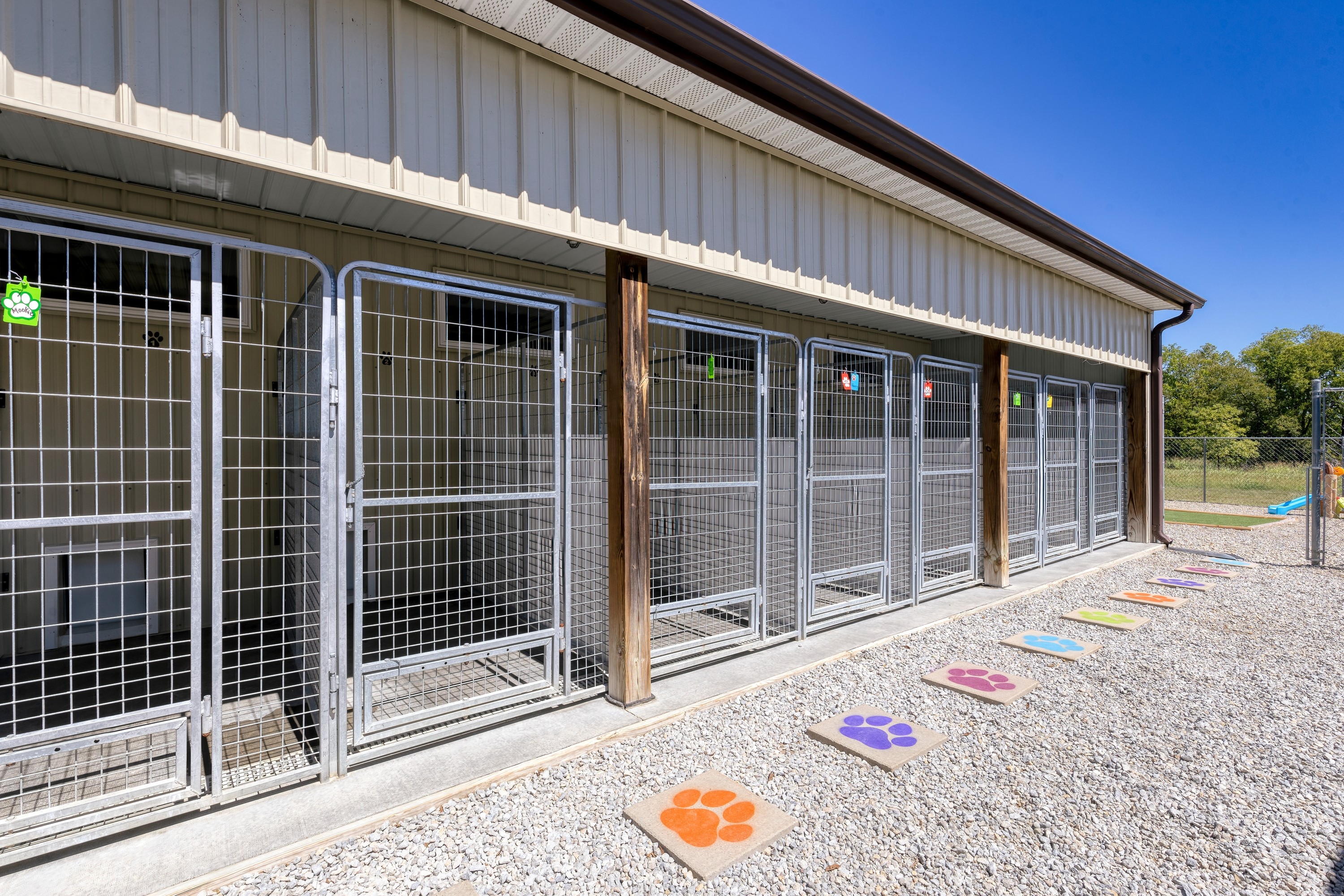 Exterior view of a building with multiple gated enclosures and a clear blue sky in the background.