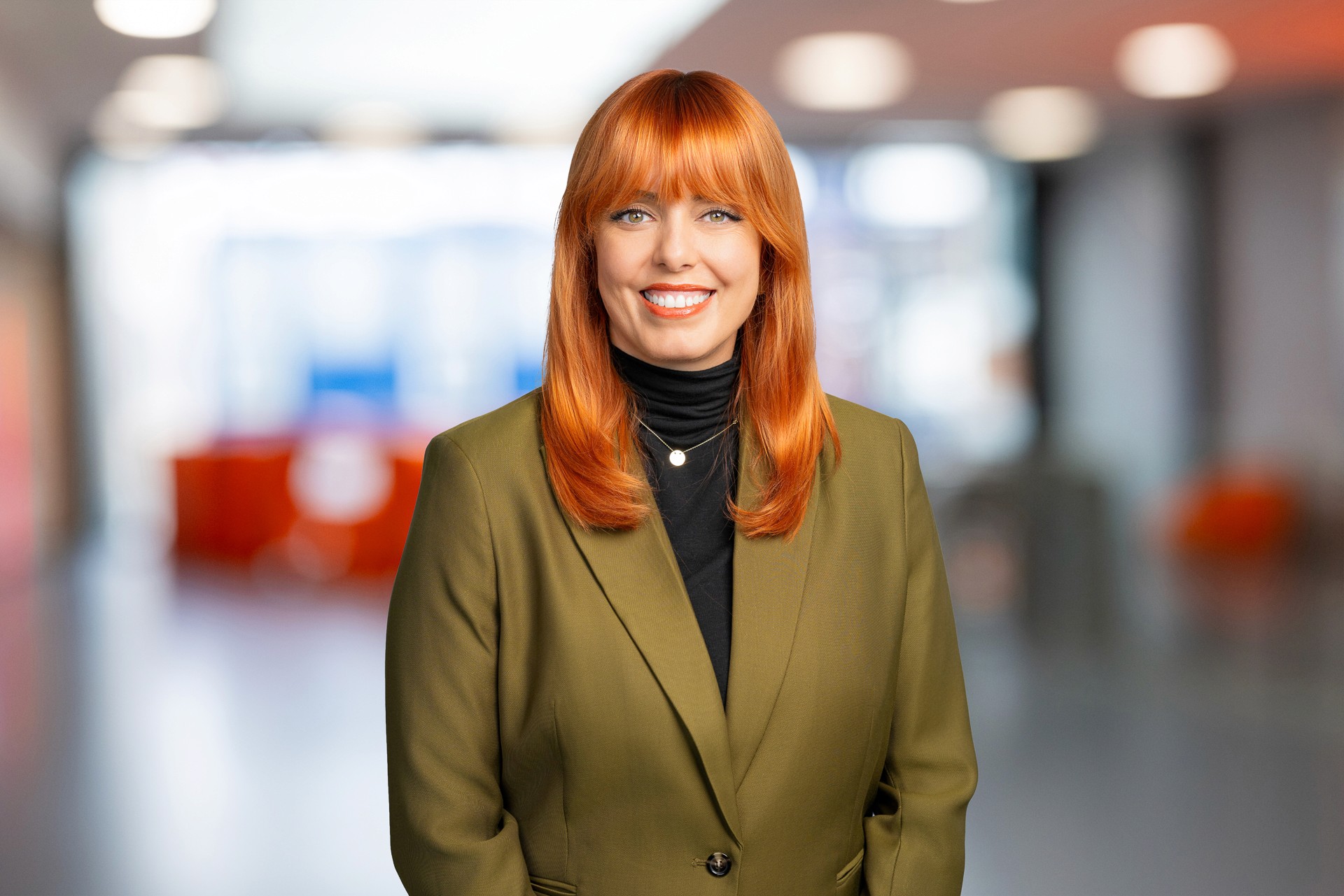 Professionelles Business Portrait mit unscharfem Bürohintergrund für authentischen Unternehmensauftritt