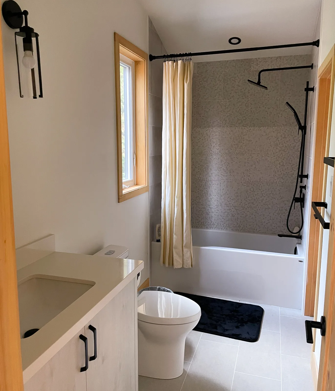 primary three-piece bathroom with full bathtub and custom tiled floor.