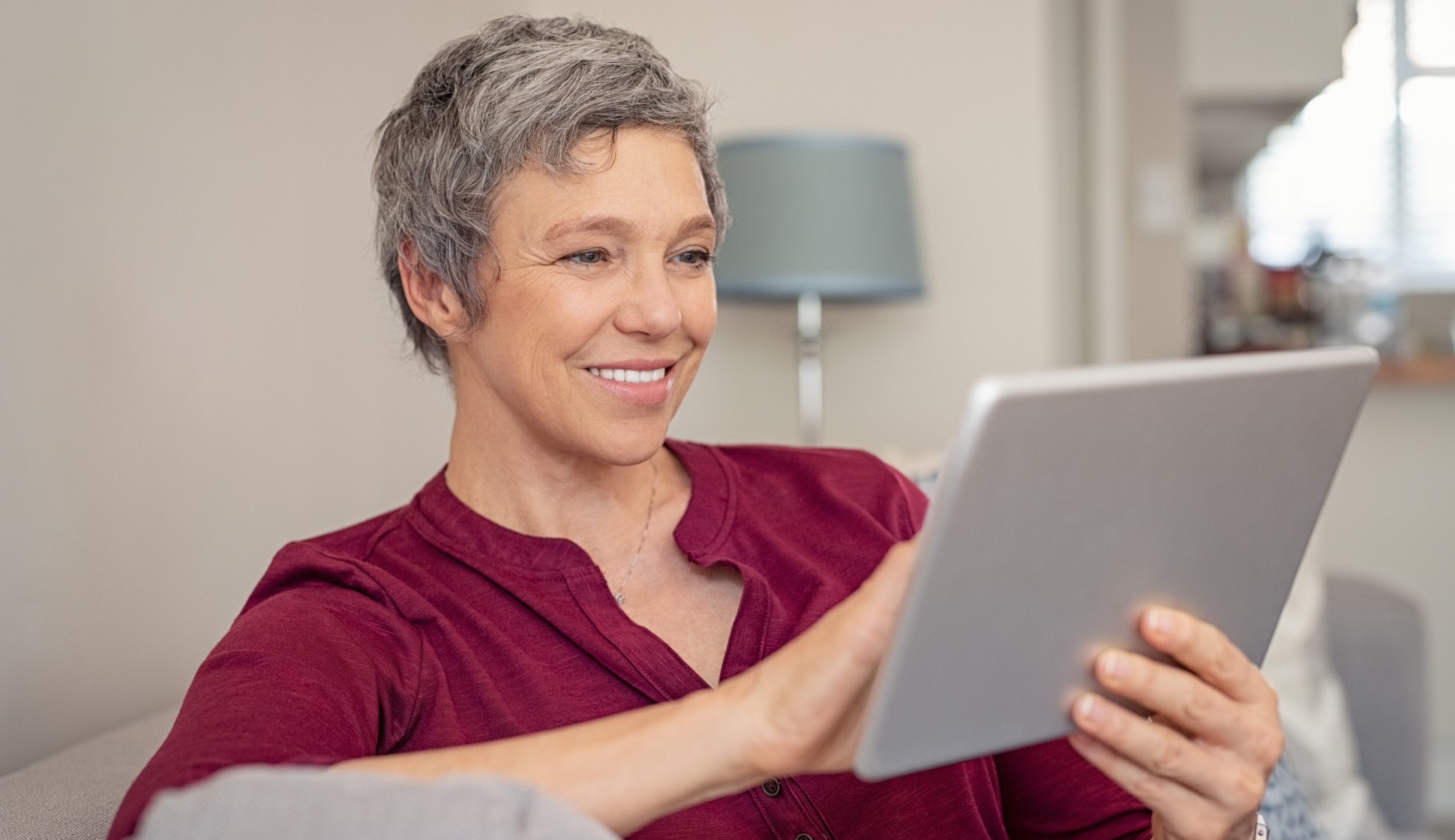 photograph of a woman in her 50s looking at a tablet