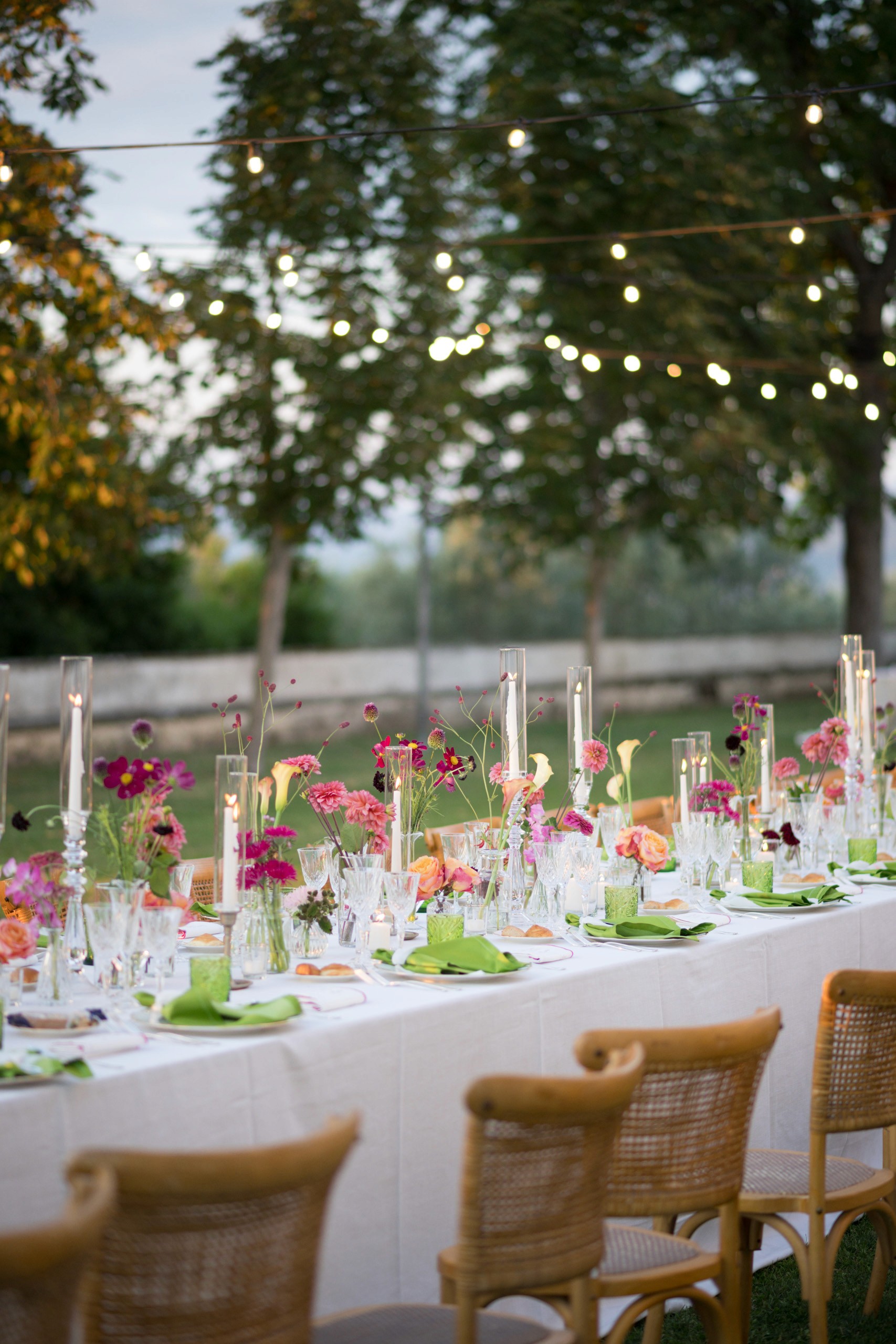 Allestimento tavola per matrimonio ed evento aziendale con luxury catering, fiori colorati, candele e mise en place elegante all’aperto