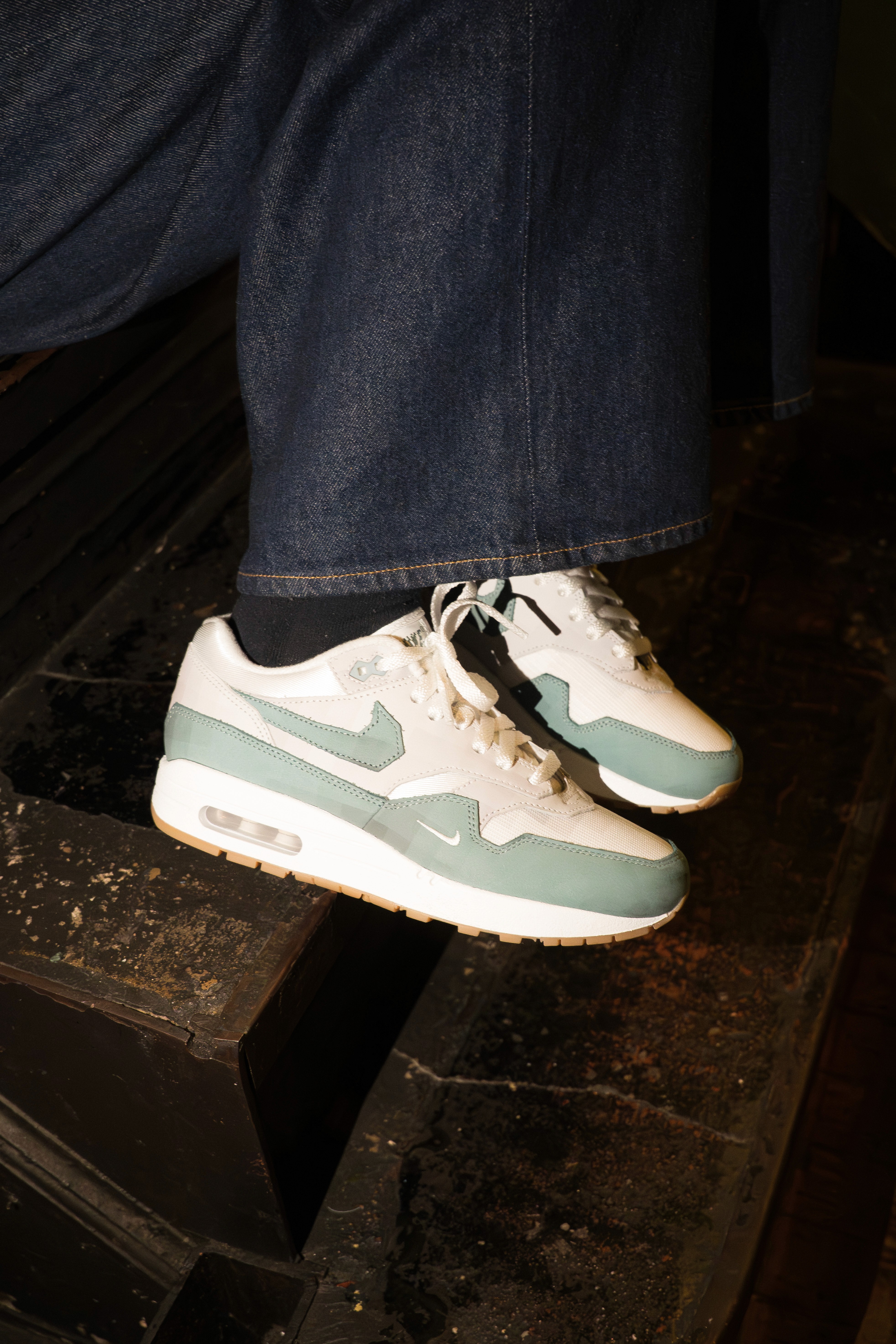 Close-up of two-tone sneakers on dark stairs, shot as lifestyle product content for EXP.Pack.