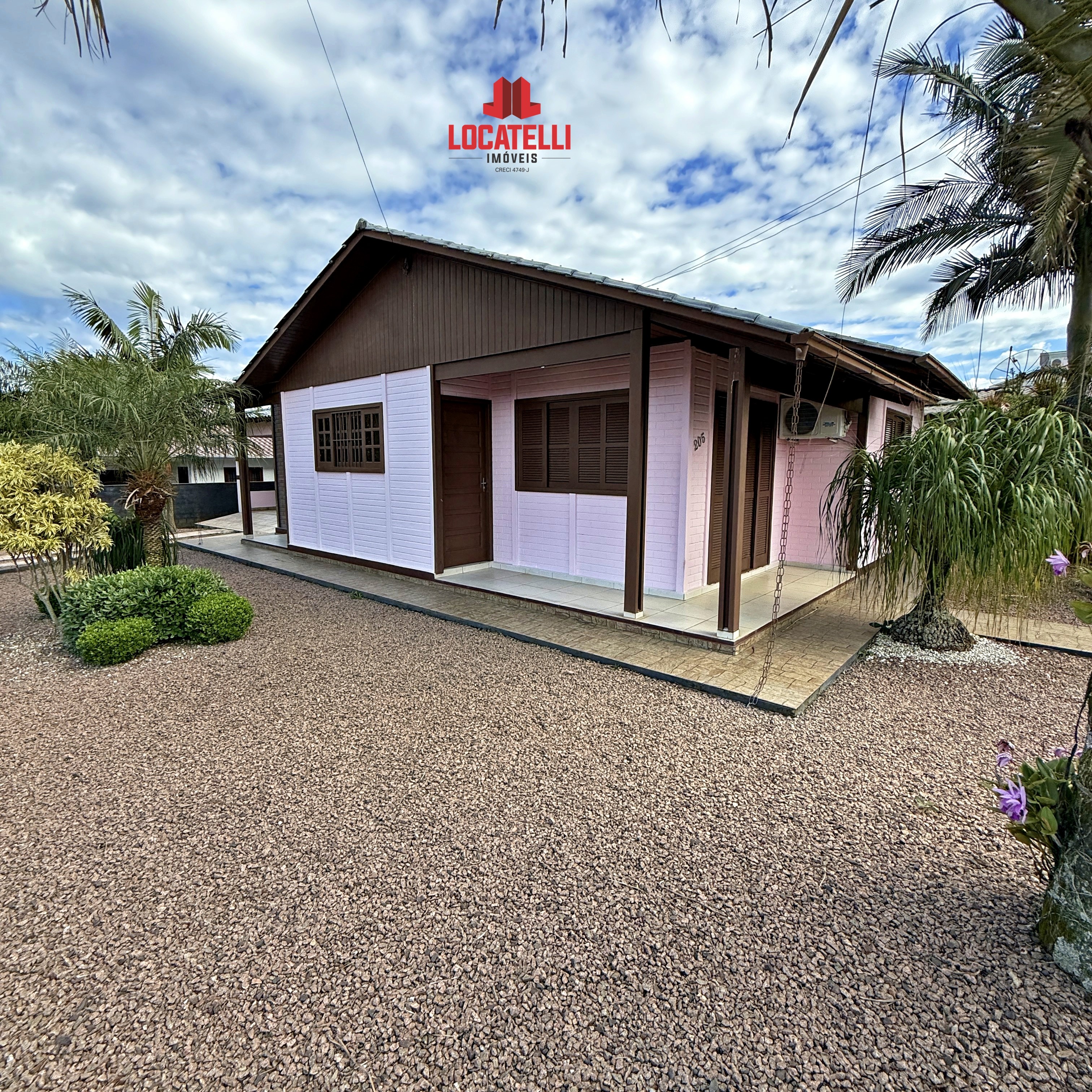 A modern brick house with a two-car garage, well-manicured lawn, and clear blue sky in the background.