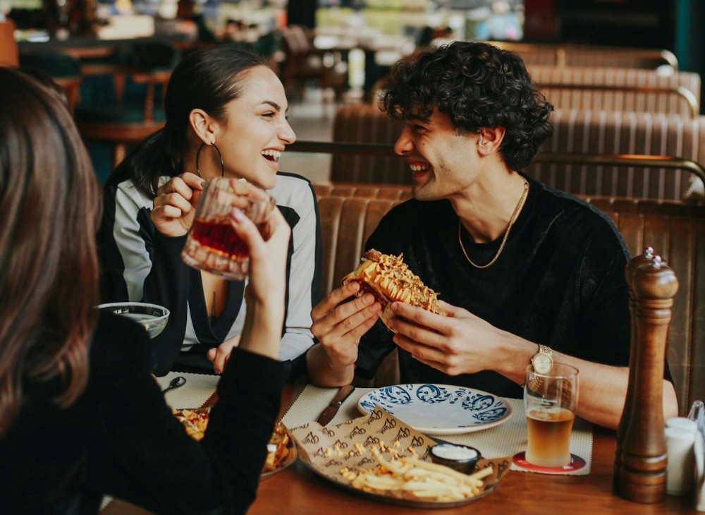 Personas compartiendo un almuerzo, metáfora de la diversificación en finanzas