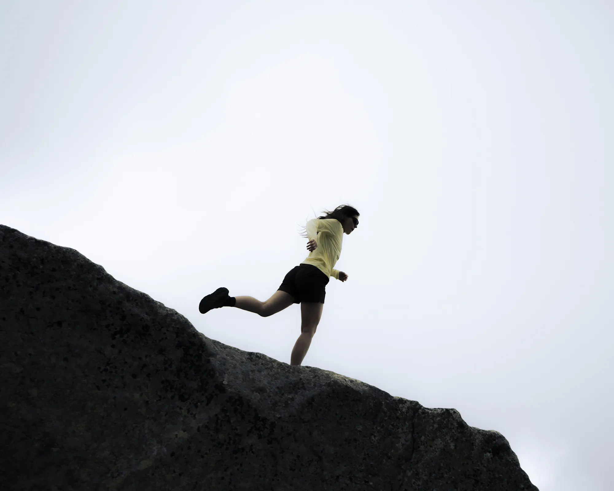 picture of a running woman on a mountain ridge.