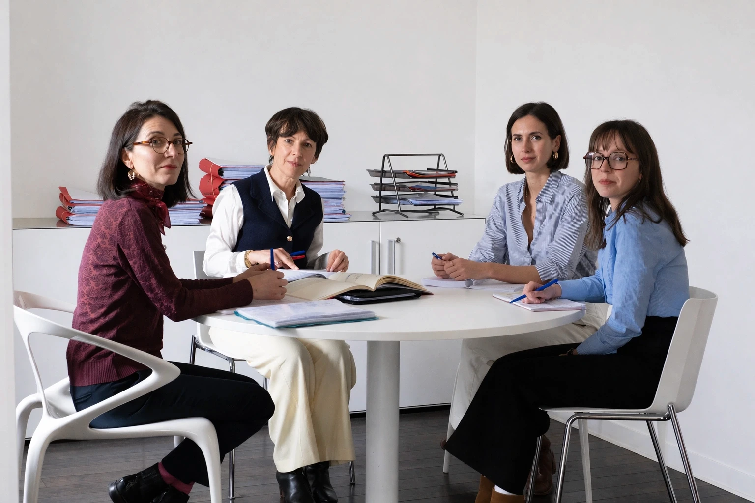 three people sitting in front of table laughing together
