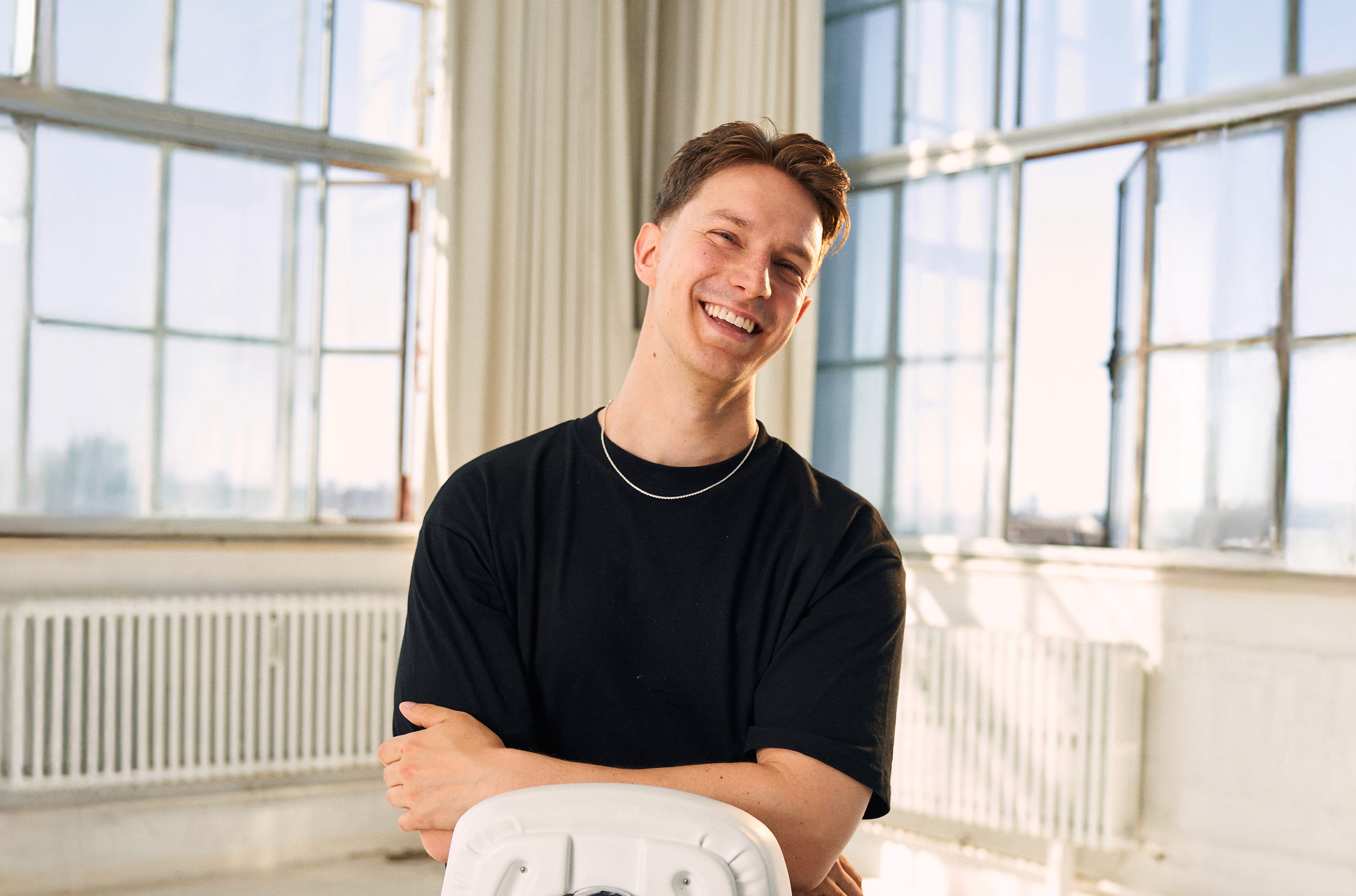 A close-up of a pink cocktail in a martini glass, set against a nighttime background with soft, blurred colors.