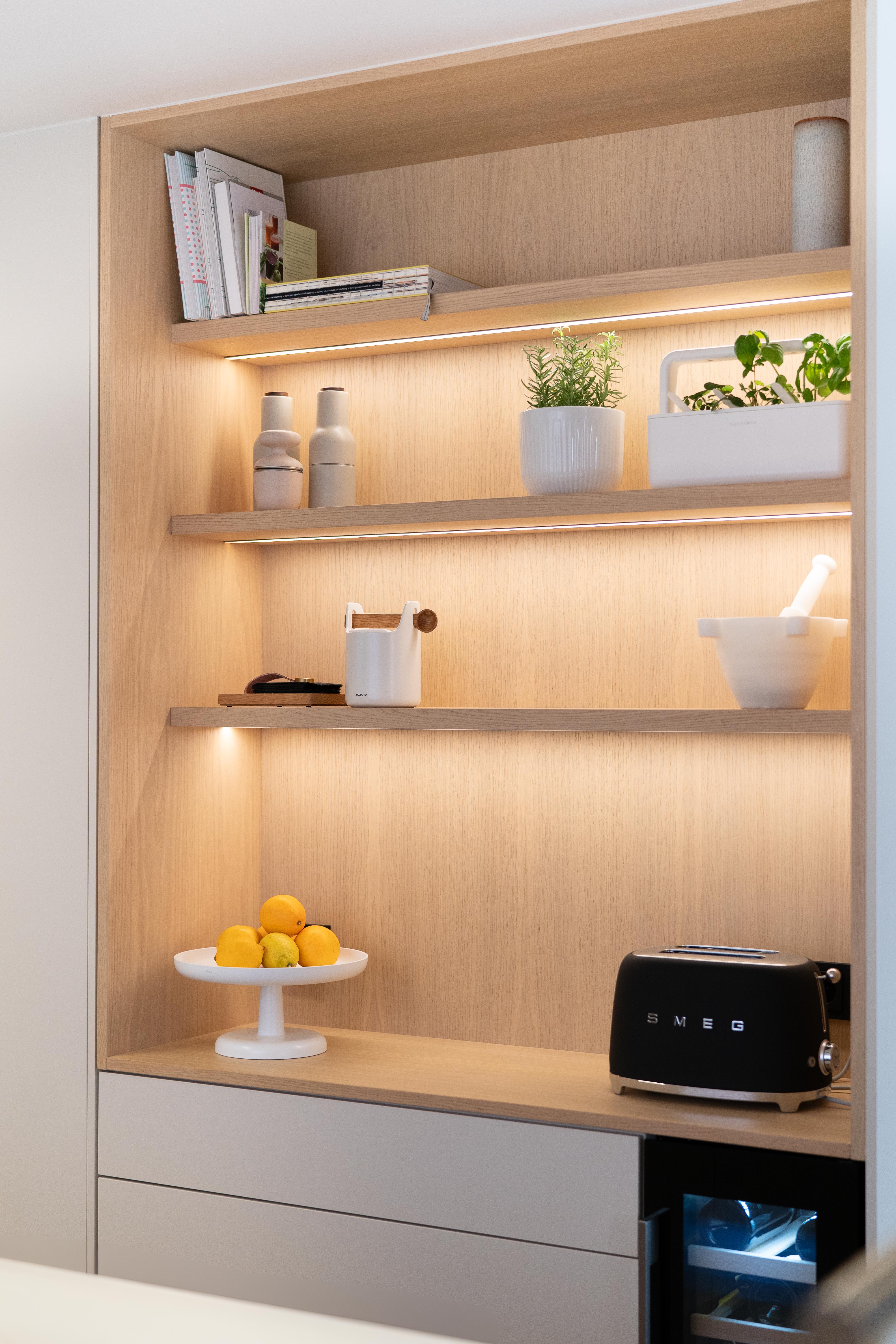 Zona desayunador con muebles blancos y estanterias de madra